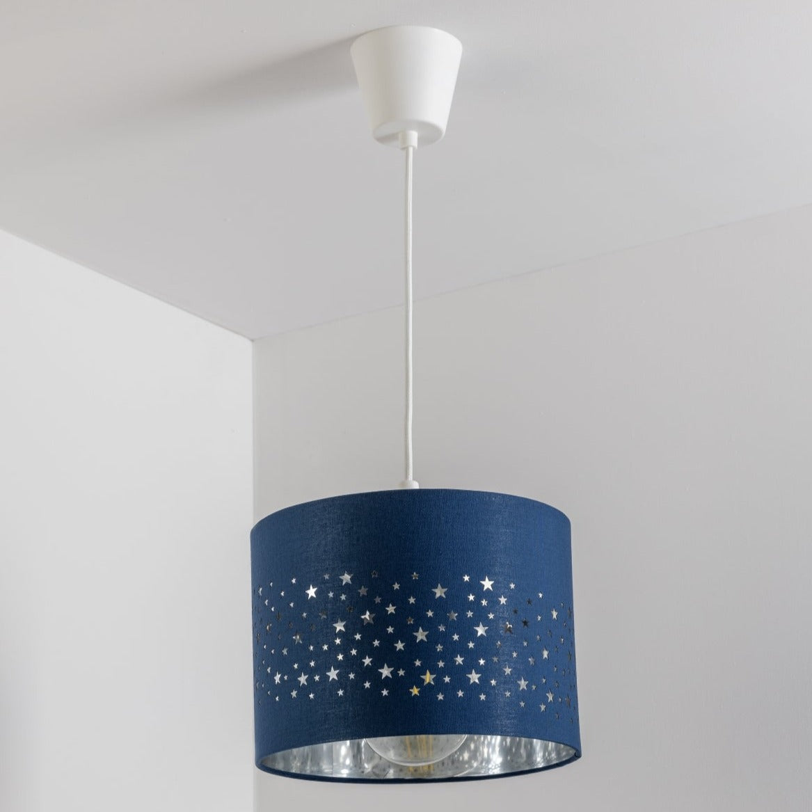 The Stardust luxury navy fabric star pendant shade would make a charming touch to your room. Constructed from a high quality soft navy cotton material with intricate laser cut stars in various sizes making a stunning effect in the room when lit. This easy fit non electrical pendant lampshade and can simply be fitted over any standard light fitting or table lamp.