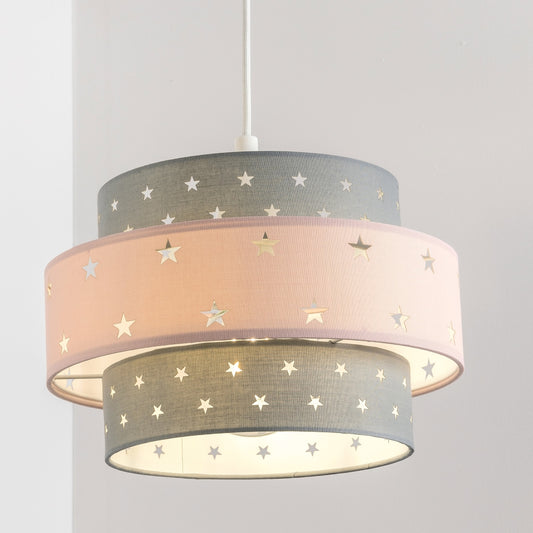 Our grey and pink two tiered star shade features a mixture of large and small sweet stars cut out across a grey and pink background. When your lamp is turned on it will shine out through these cut-outs, mimicking a beautiful night sky. This lampshade is made with soft-touch fabric for a little bit of luxury.