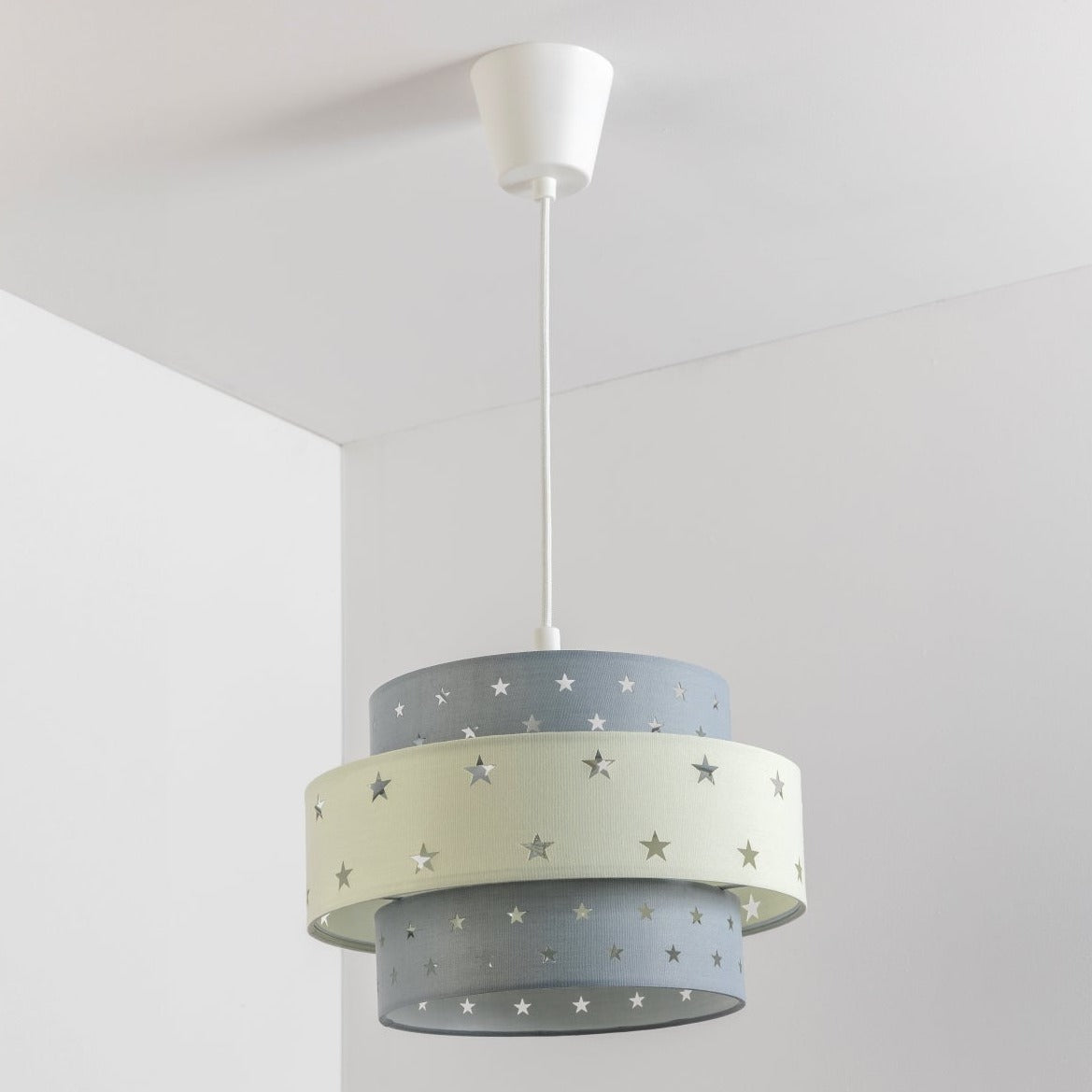 Our Grey and Cream two tiered star shade features a mixture of large and small sweet stars cut out across a grey and cream background. When your lamp is turned on it will shine out through these cut-outs, mimicking a beautiful night sky. This lampshade is made with soft-touch fabric for a little bit of luxury.