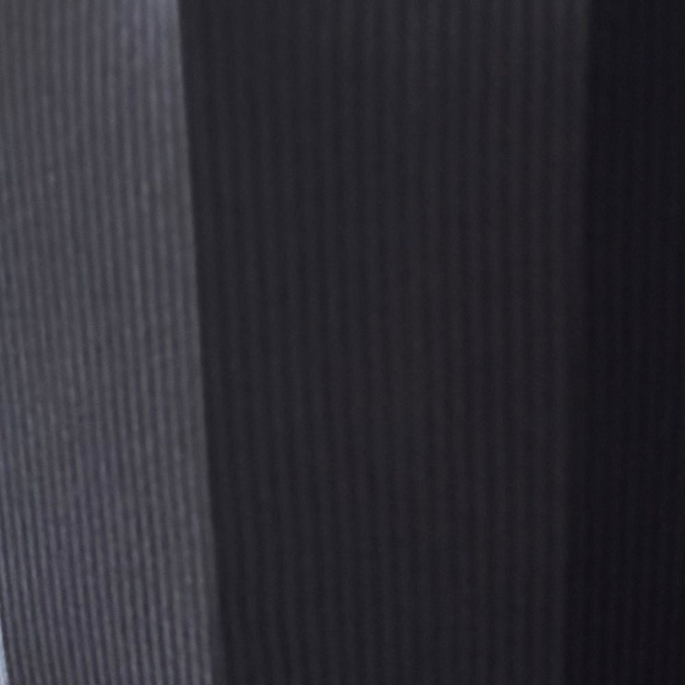 Close-up of a textured fabric with a gradient from gray to black.