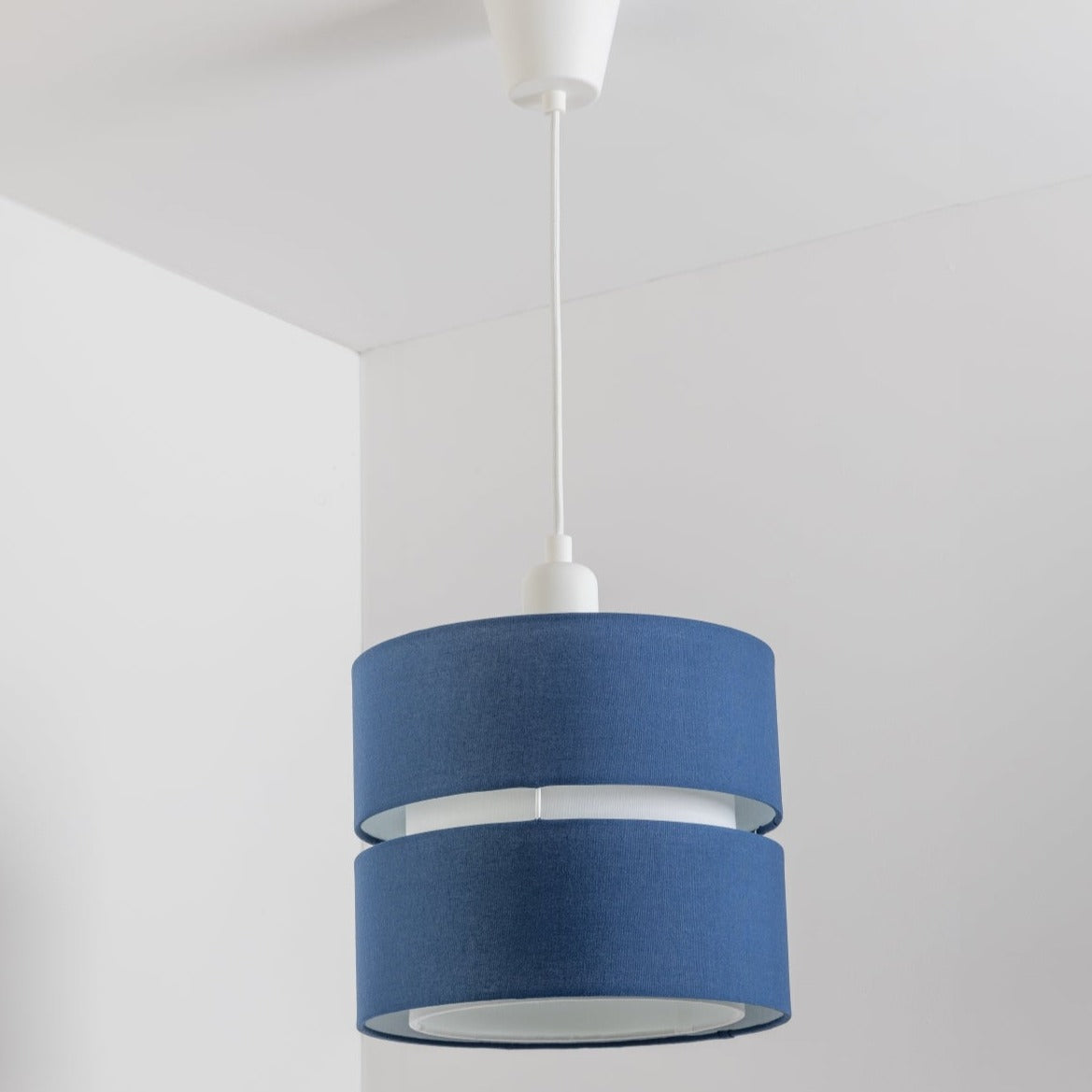 Our Gayle easy fit two tiered luxury fabric double layered shade is contemporary in its appearance and we have designed the shade to suit a range of interiors. Easy to fit simply attached to an existing pendant flitting.  It is crafted from high quality fabric material in two layers and complimented with a white inner which looks beautiful when light shines through. The shade has been made to fit both a ceiling light or lamp base.
