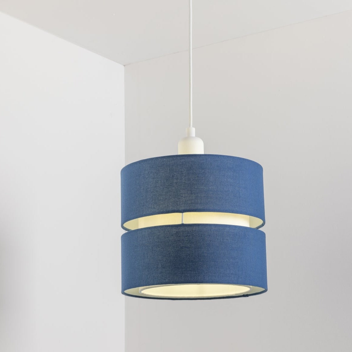 Our Gayle easy fit two tiered luxury fabric double layered shade is contemporary in its appearance and we have designed the shade to suit a range of interiors. Easy to fit simply attached to an existing pendant flitting.  It is crafted from high quality fabric material in two layers and complimented with a white inner which looks beautiful when light shines through. The shade has been made to fit both a ceiling light or lamp base.