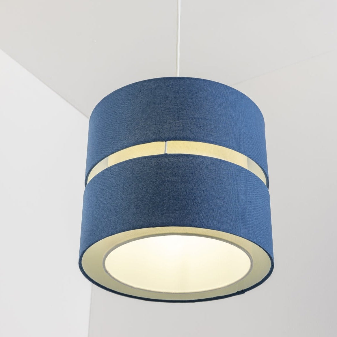 Our Gayle easy fit two tiered luxury fabric double layered shade is contemporary in its appearance and we have designed the shade to suit a range of interiors. Easy to fit simply attached to an existing pendant flitting.  It is crafted from high quality fabric material in two layers and complimented with a white inner which looks beautiful when light shines through. The shade has been made to fit both a ceiling light or lamp base.