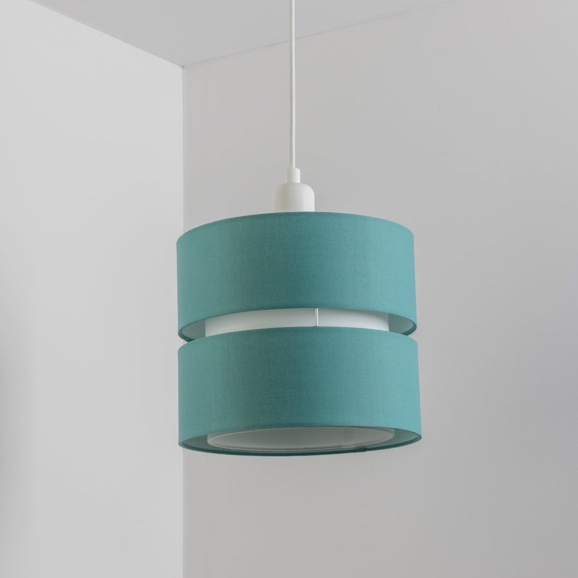 Our Gayle easy-fit two tiered luxury fabric double layered shade is contemporary in its appearance and we have designed the shade to suit a range of interiors. Easy to fit simply attached to an existing pendant flitting.  It is crafted from high quality fabric material in two layers and complimented with a white inner which looks beautiful when light shines through. The shade has been made to fit both a ceiling light or lamp base.