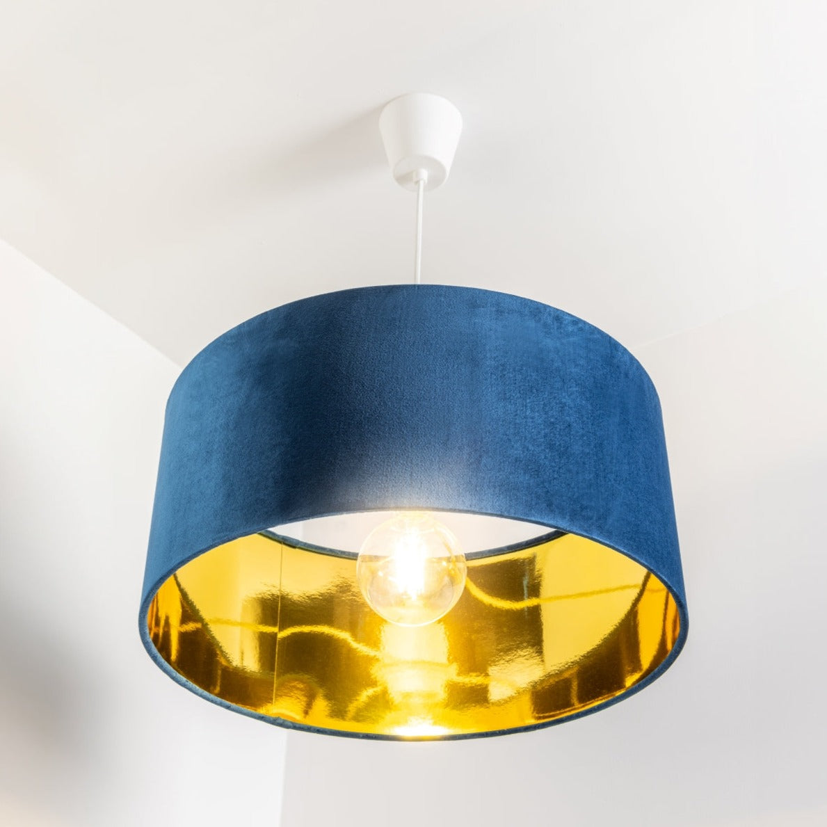 Our stunning oversized navy Milano lamp shade offers a timeless update to any room. The outer is made from high-quality navy blue velvet and the lining is reflective gold for a stylish finish. It’s easy to install and will instantly transforms your ceiling fitting, table or floor lamp. Simply attach to an existing light fitting or lamp base for an instant glow up.