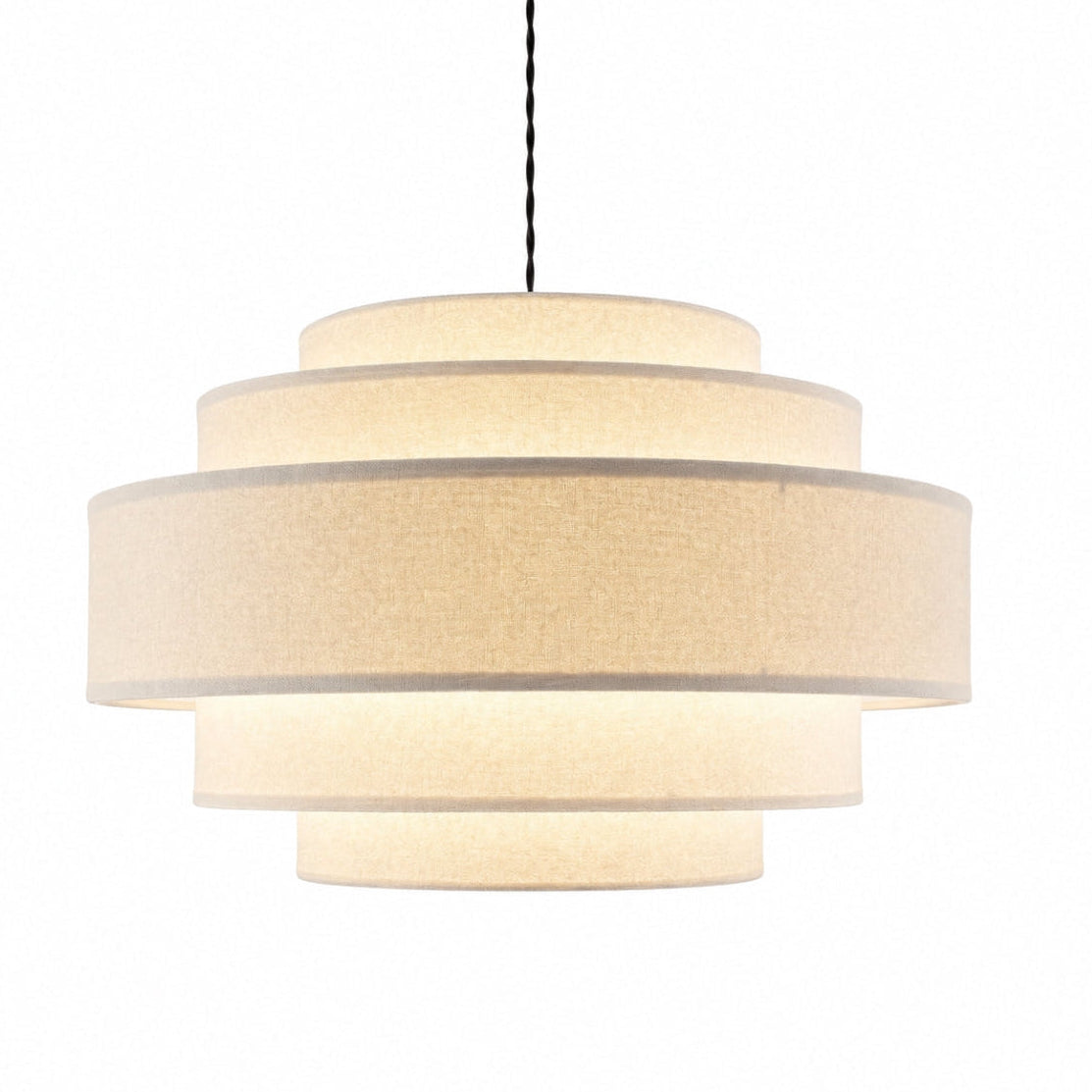 A modern three-tiered drum pendant light with a textured cream fabric shade, suspended by a black cord against a solid white background.