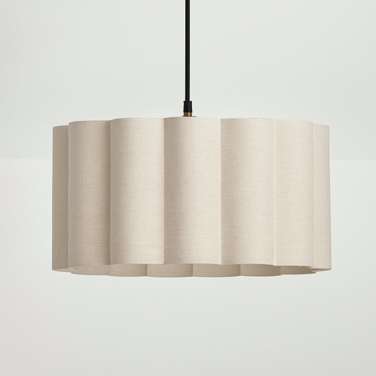 Beige pendant lamp with a textured shade on a light gray background