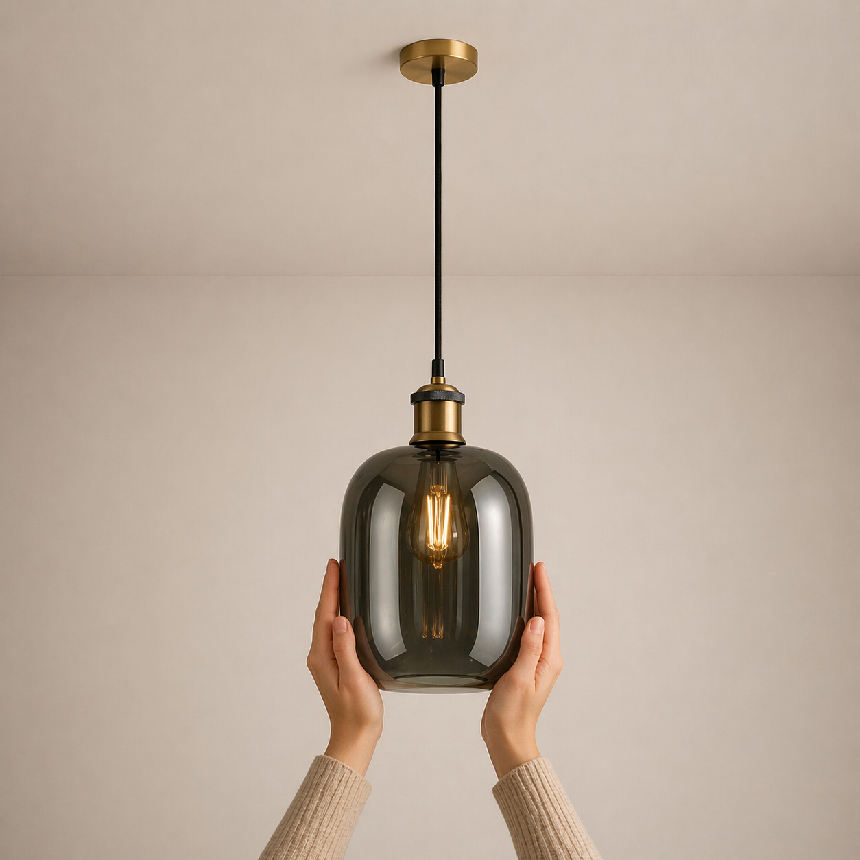Smoked glass pendant light held by a person against a beige background
