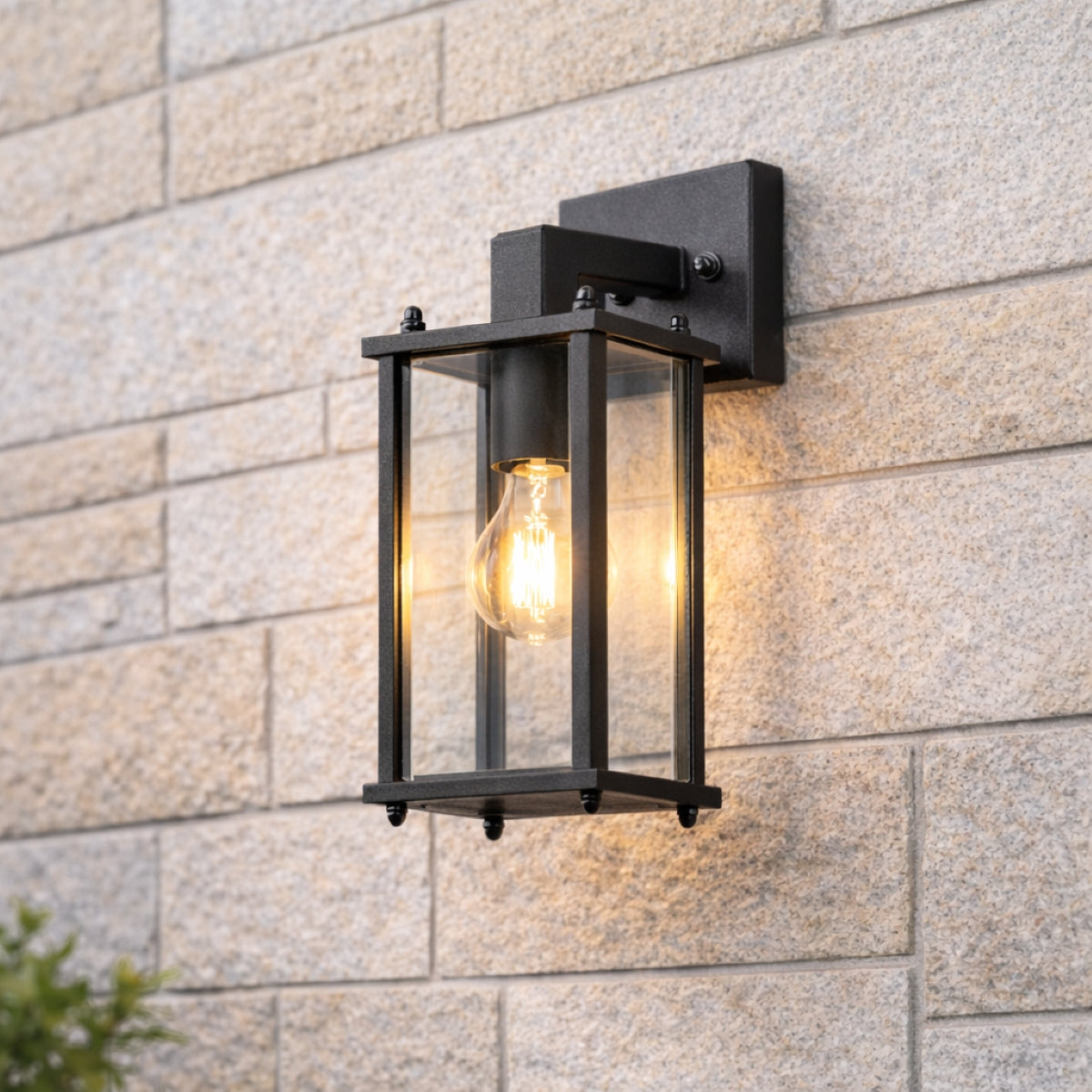 Black outdoor wall light fixture on a stone wall