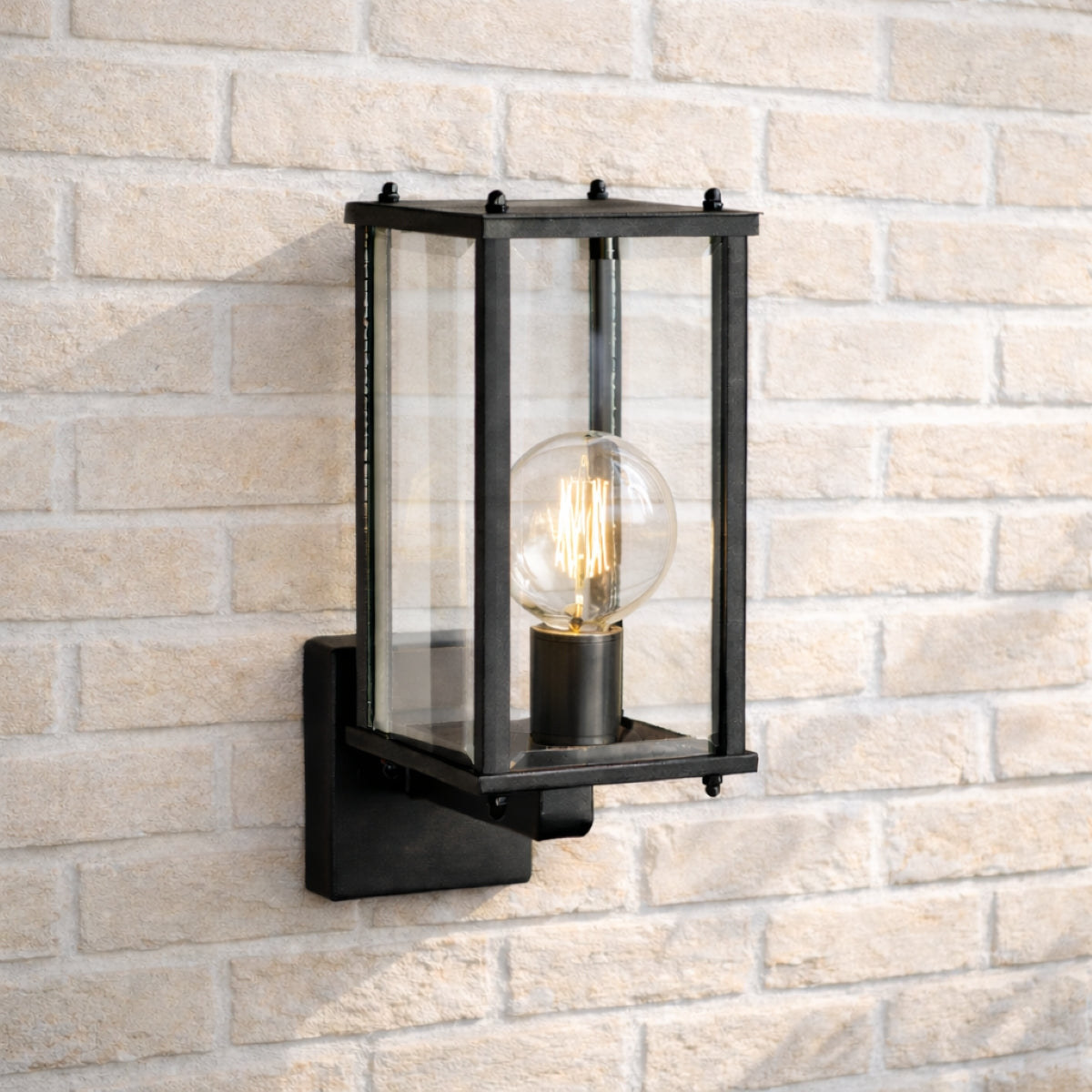 Black outdoor wall light fixture on a brick wall