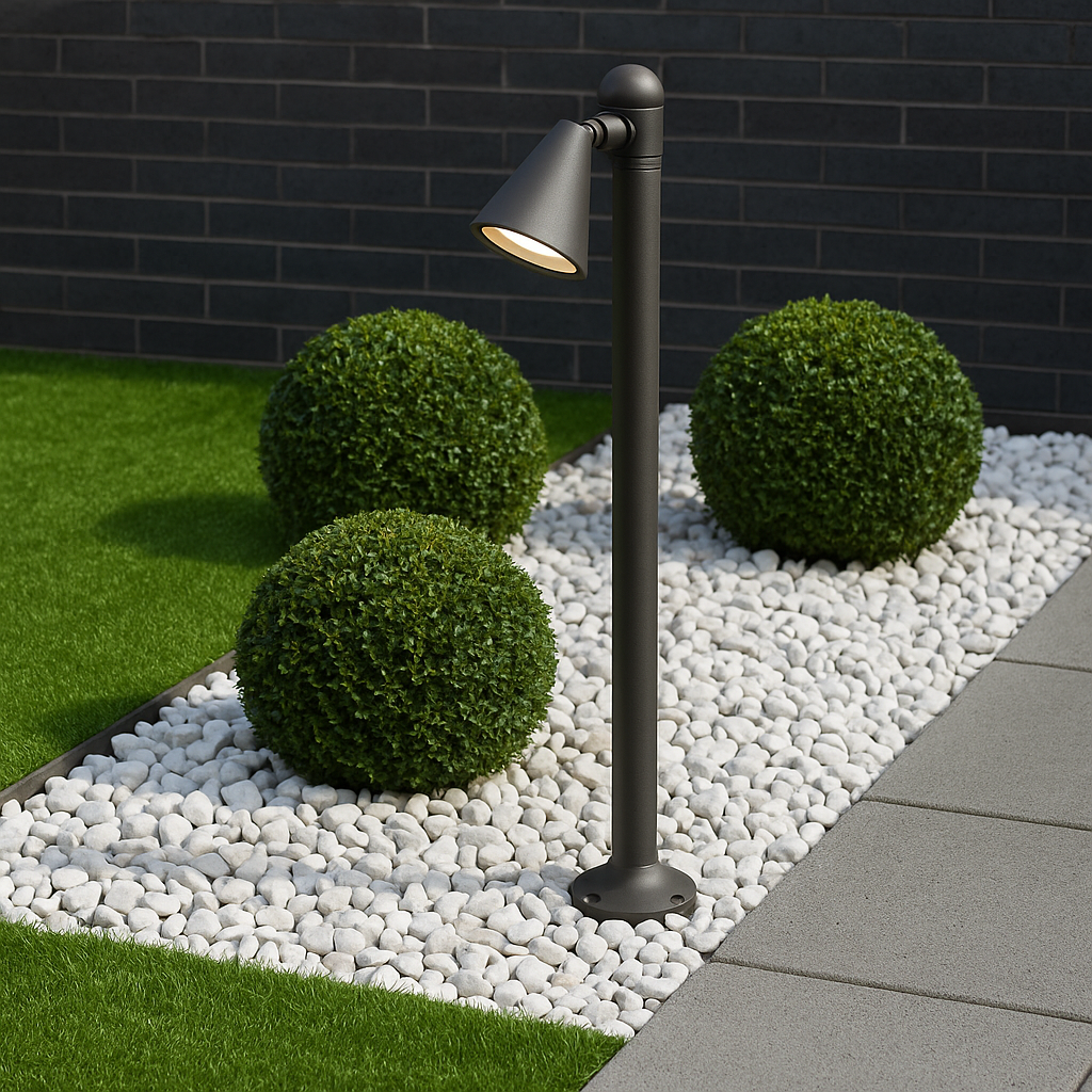 Outdoor garden light fixture on pebbles with greenery and a brick wall in the background