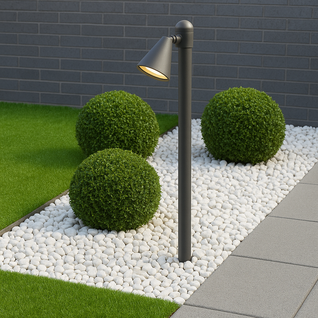 Garden light fixture with decorative pebbles and shrubs against a brick wall.