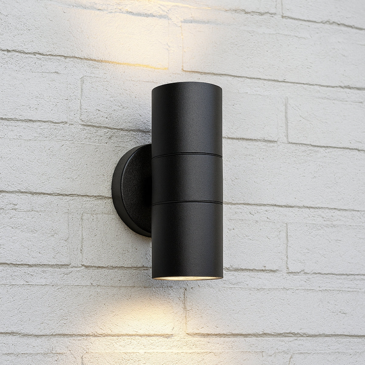 Black outdoor wall light fixture on a light brick wall