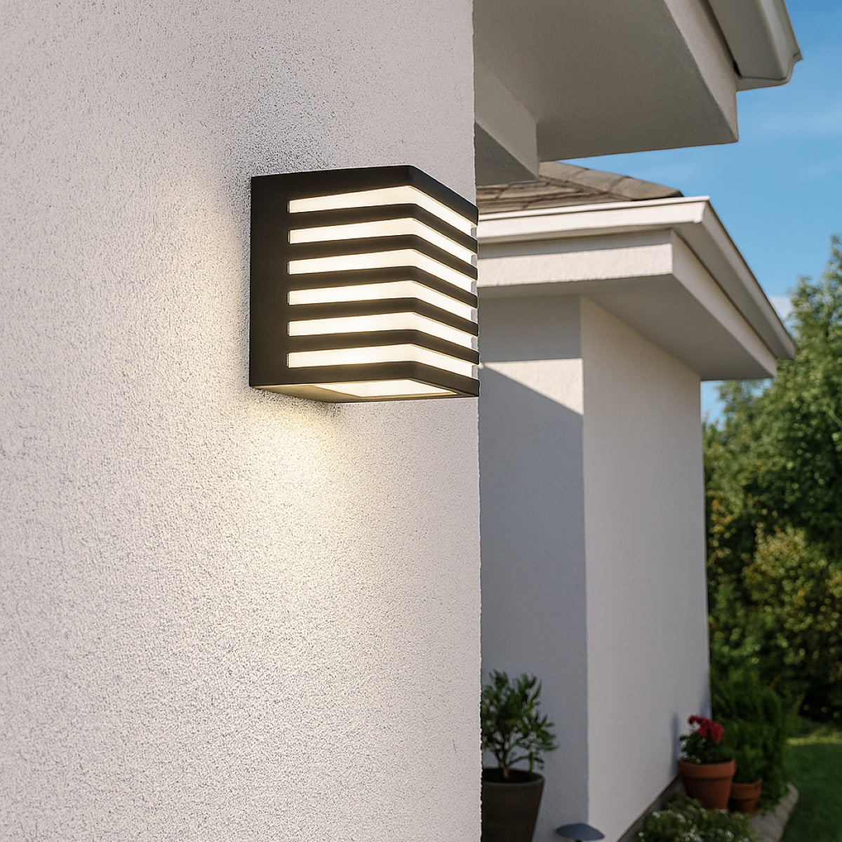 Modern outdoor wall light fixture on a house exterior with a clear sky.