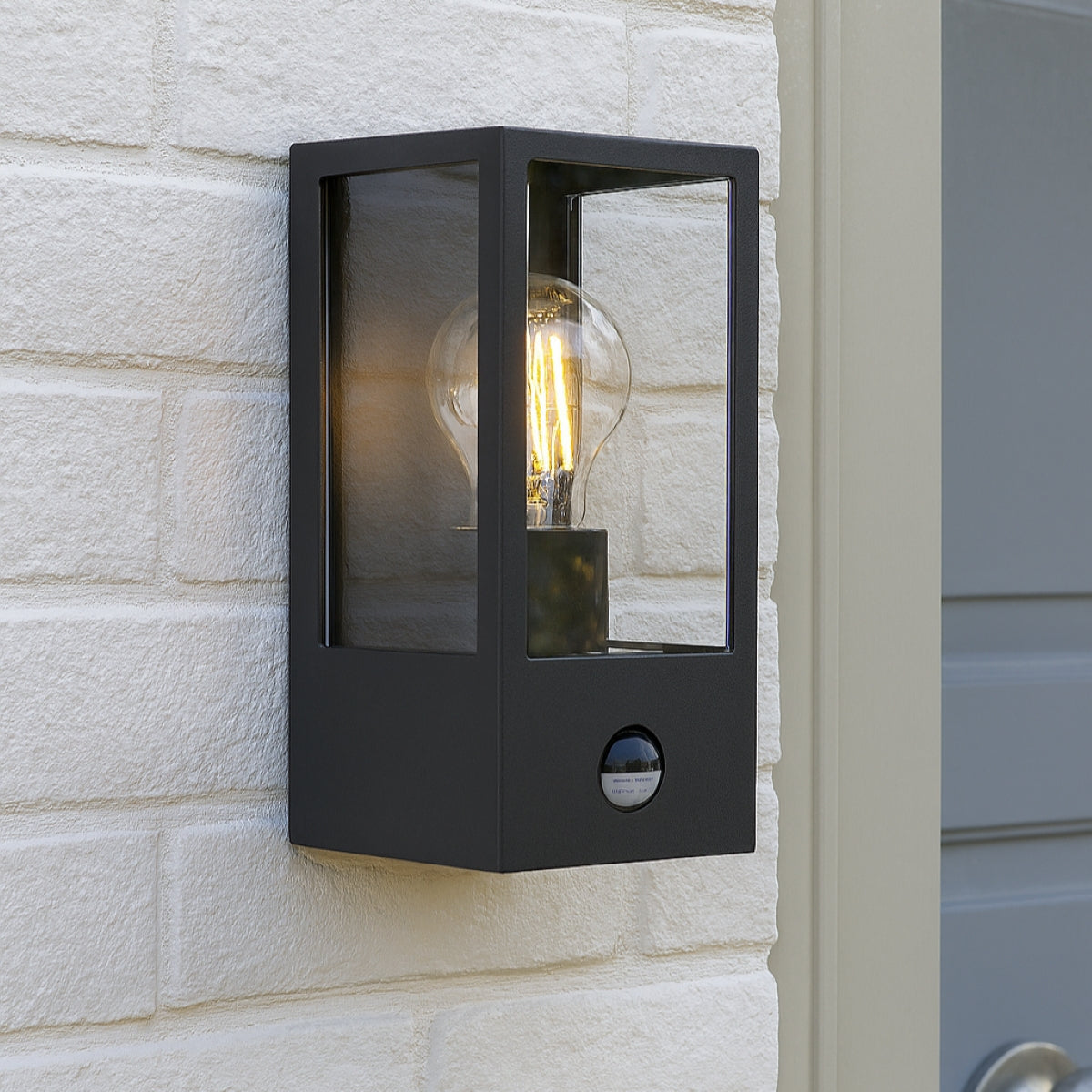 Black outdoor wall light fixture on a stone wall