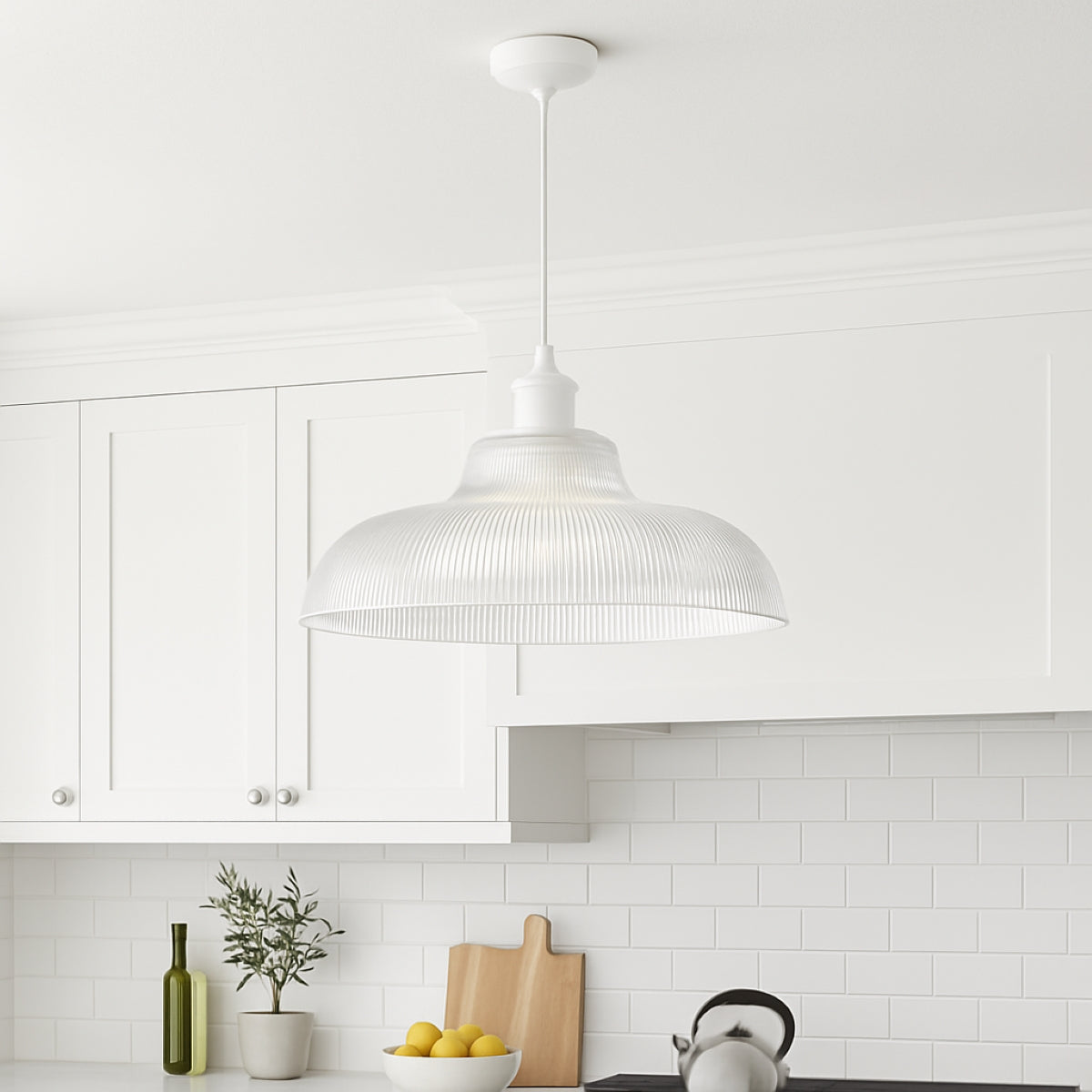 White pendant light in a modern kitchen with white cabinets and subway tiles.