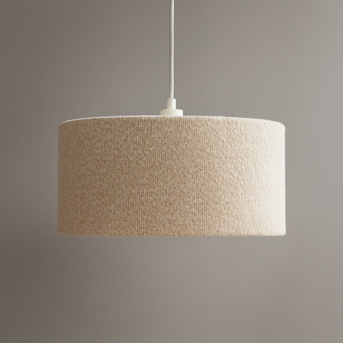 Textured beige pendant lamp against a gray background