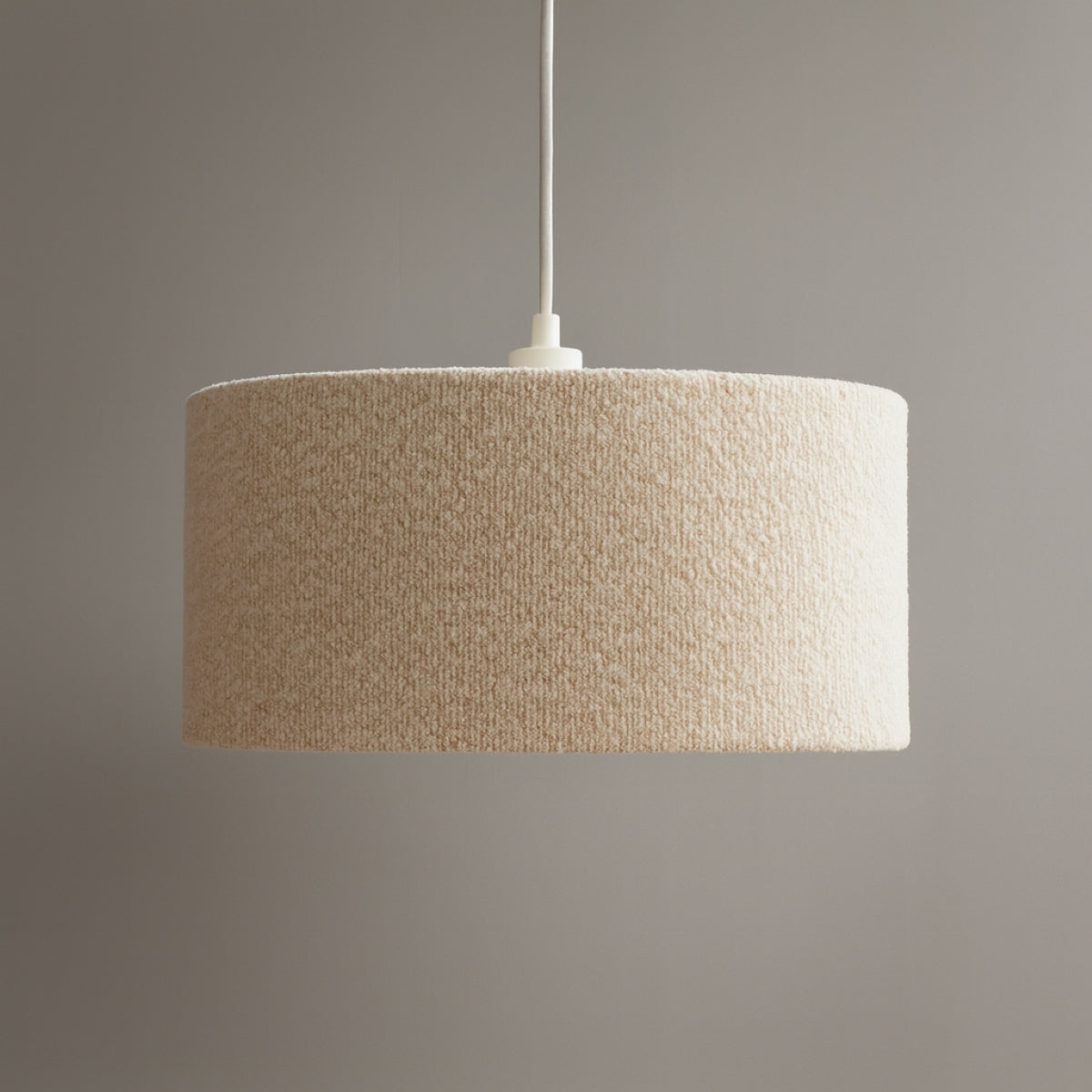 Textured beige pendant lamp against a gray background