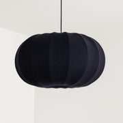 Black pendant lamp with a ribbed texture on a white background