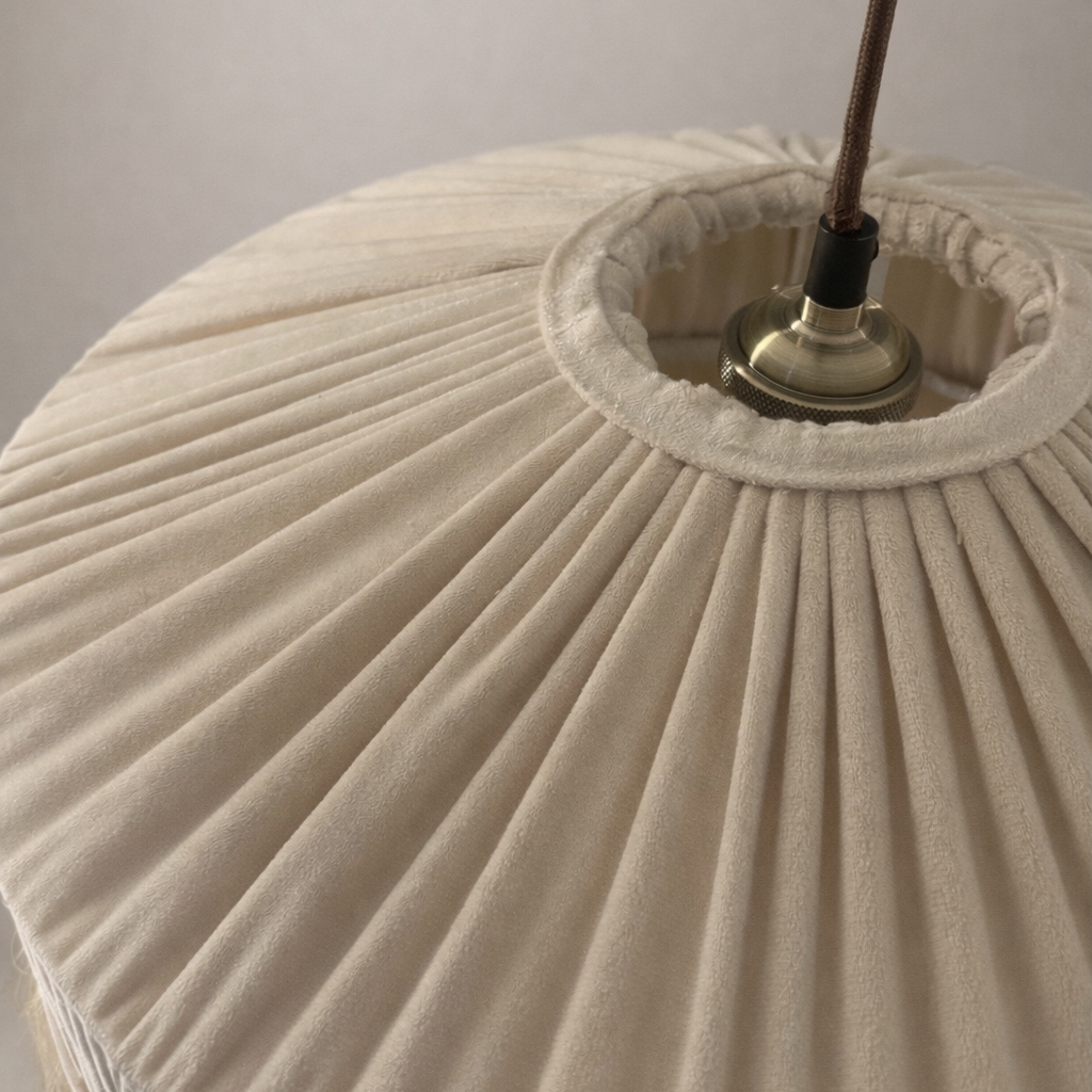 Close-up of a pleated beige lampshade with a light fixture.