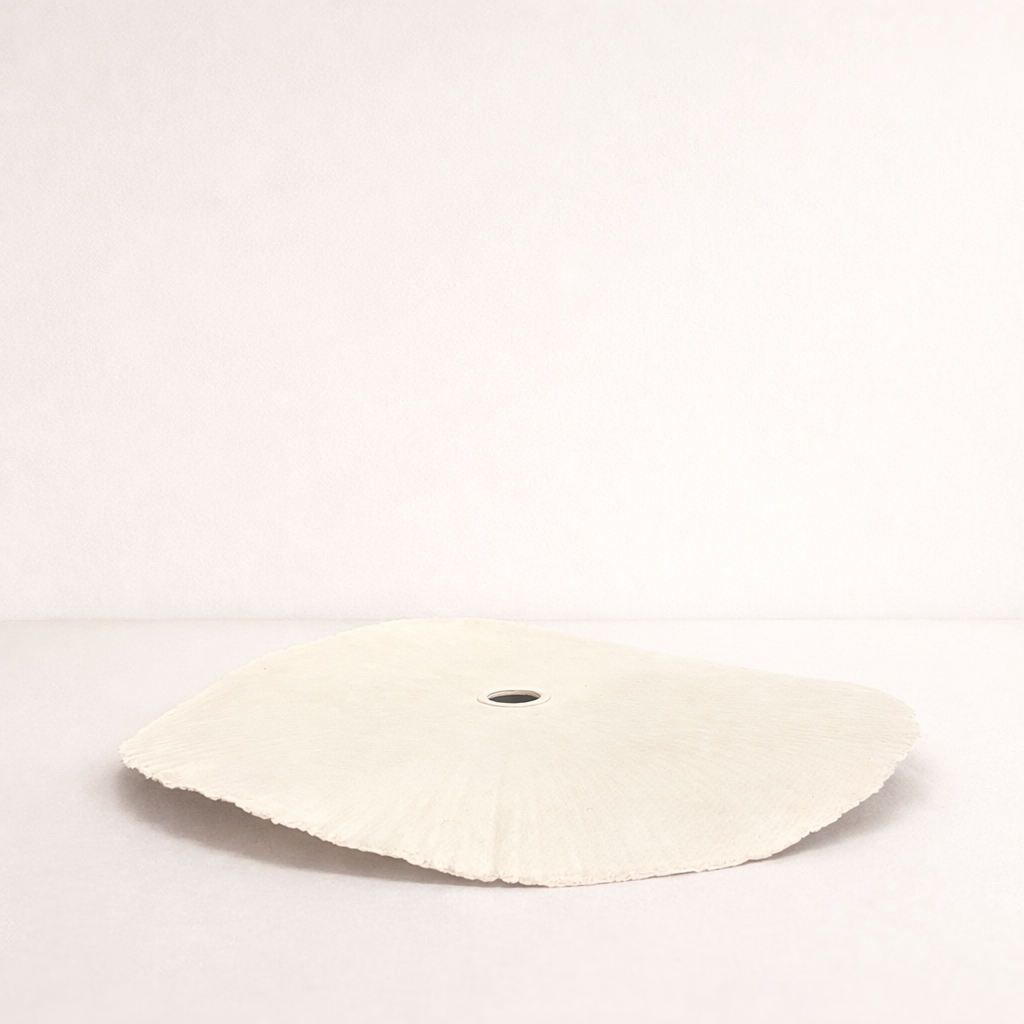 Round white object with a central hole on a light gray background