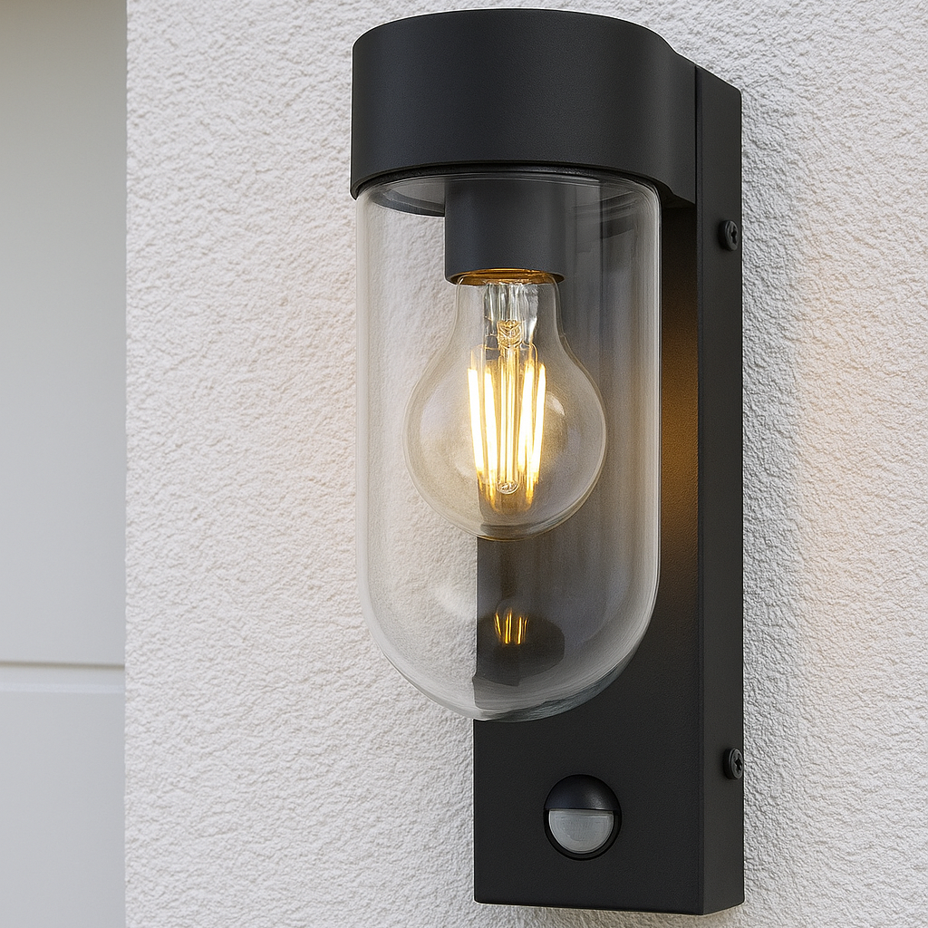 Black outdoor wall light fixture with clear glass cover on a textured white wall.
