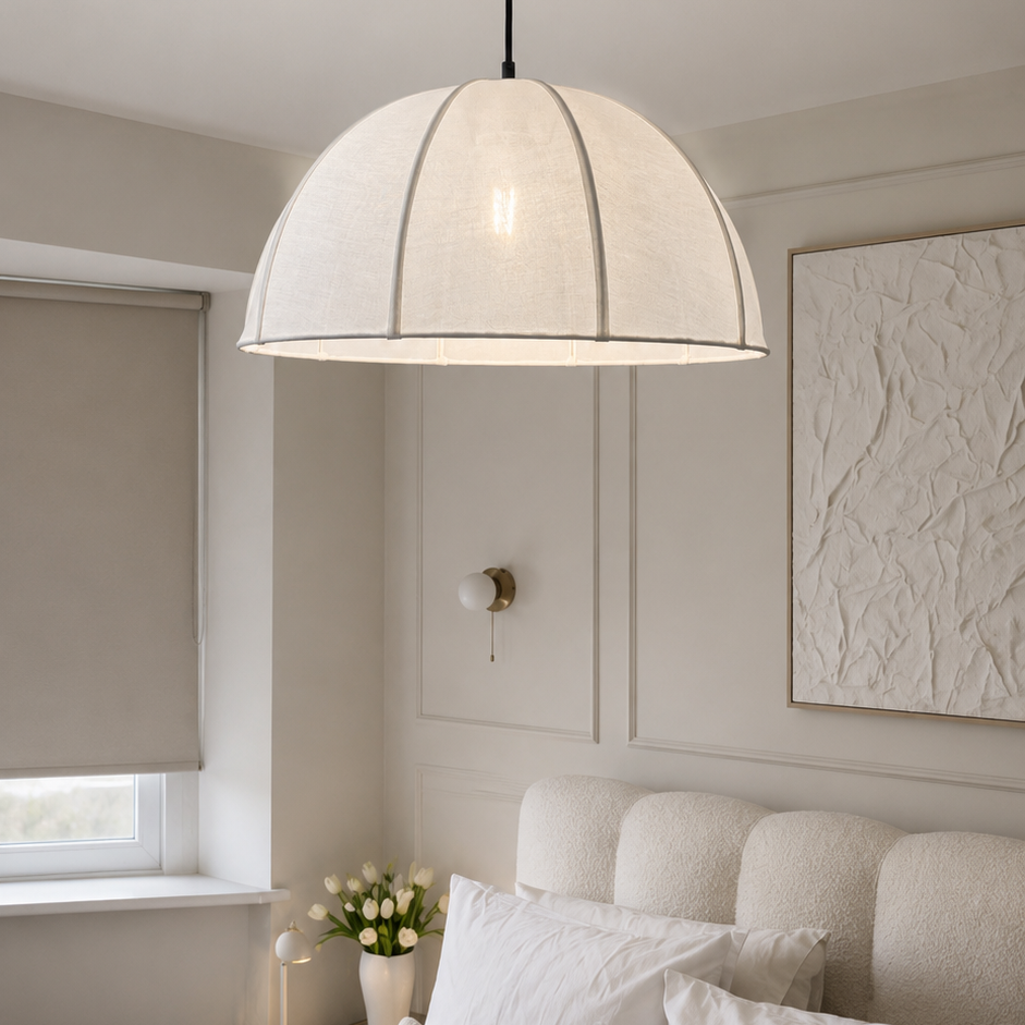 A modern dome-shaped pendant light with a textured off-white fabric shade and a dark metal canopy, hanging in a neutral-toned bedroom above a bed.