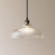 Pendant light with ribbed glass shade on a beige background