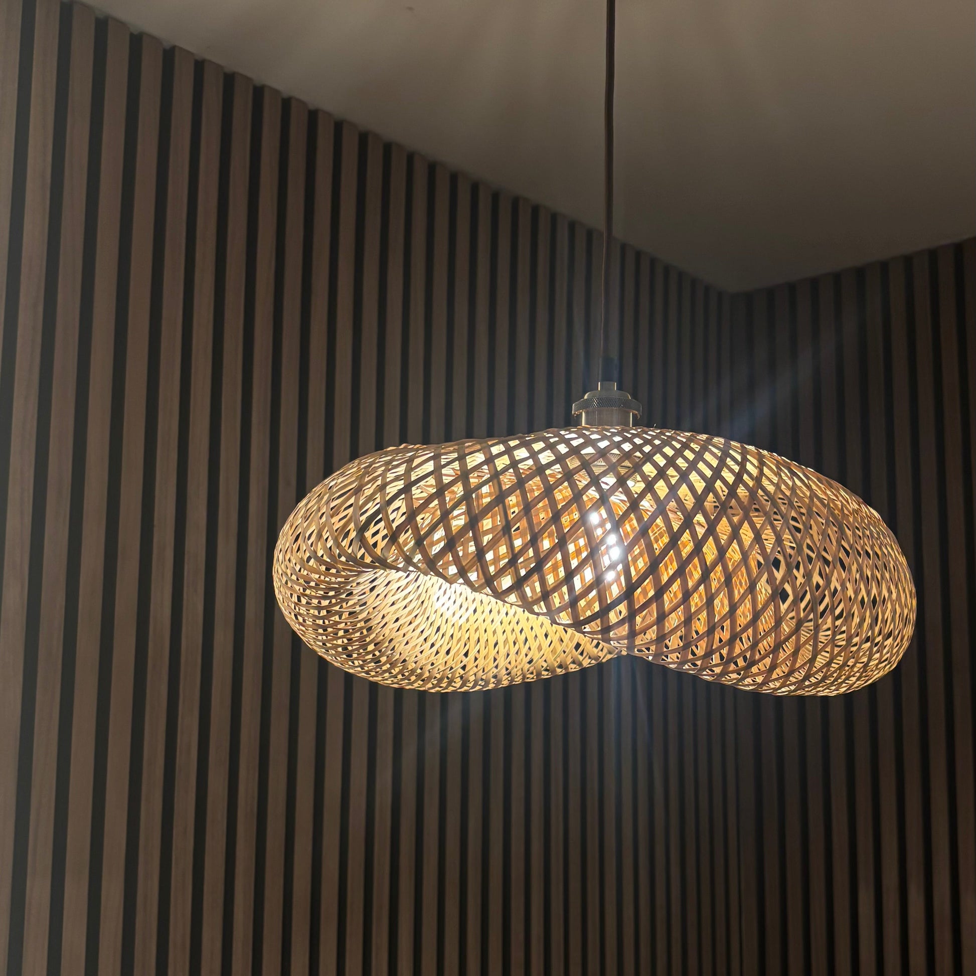Modern pendant light hanging against a striped wall