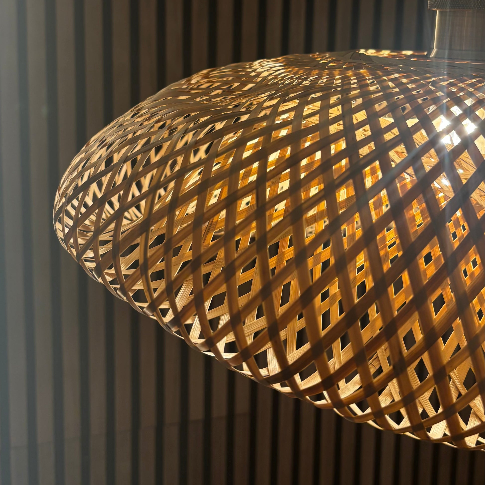 Close-up of a woven wooden lampshade against a dark background