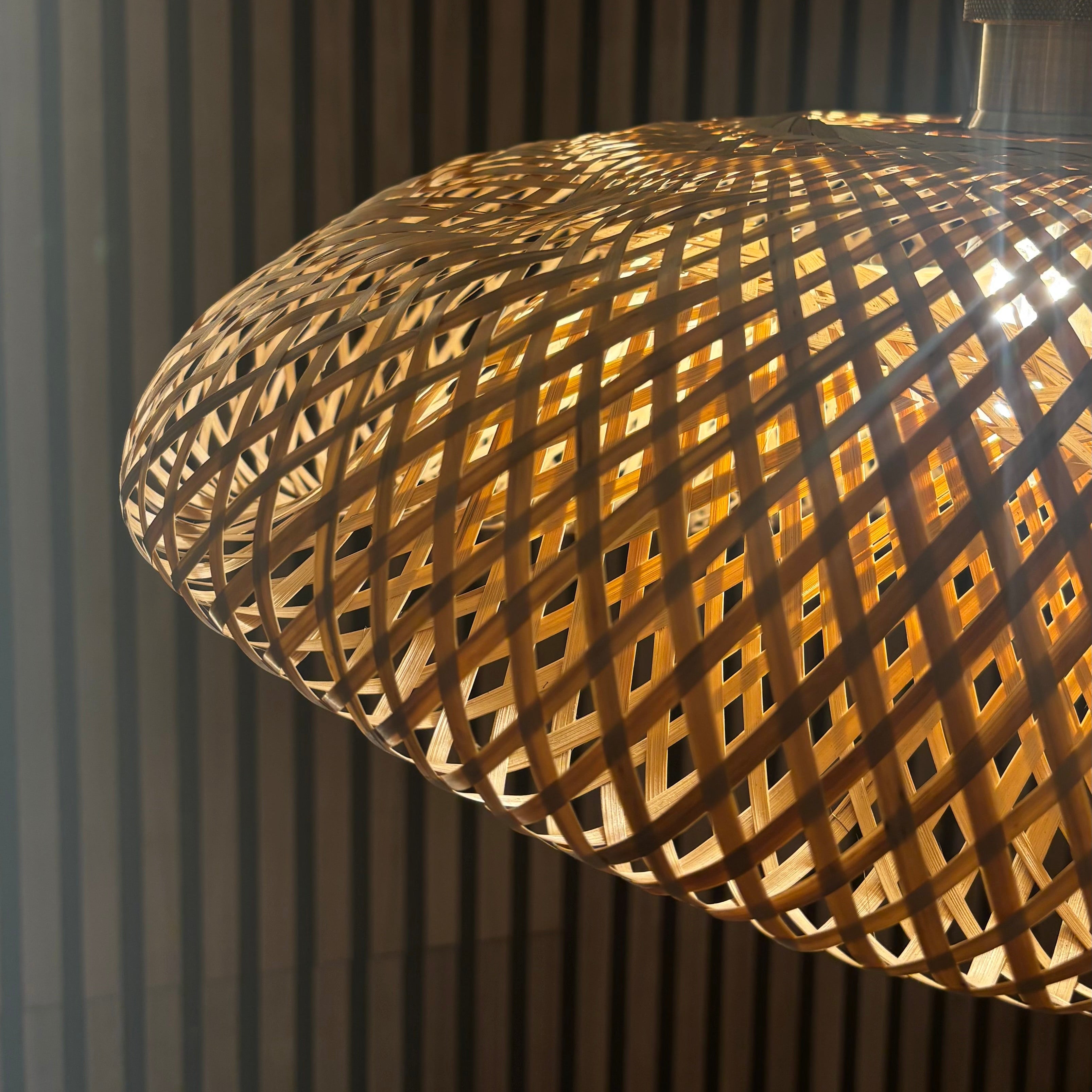 Close-up of a woven wooden lampshade against a dark background