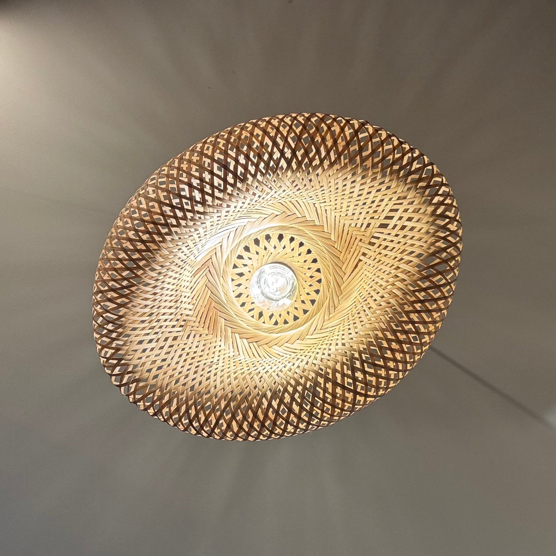 Ceiling light fixture with a textured design on a plain wall.