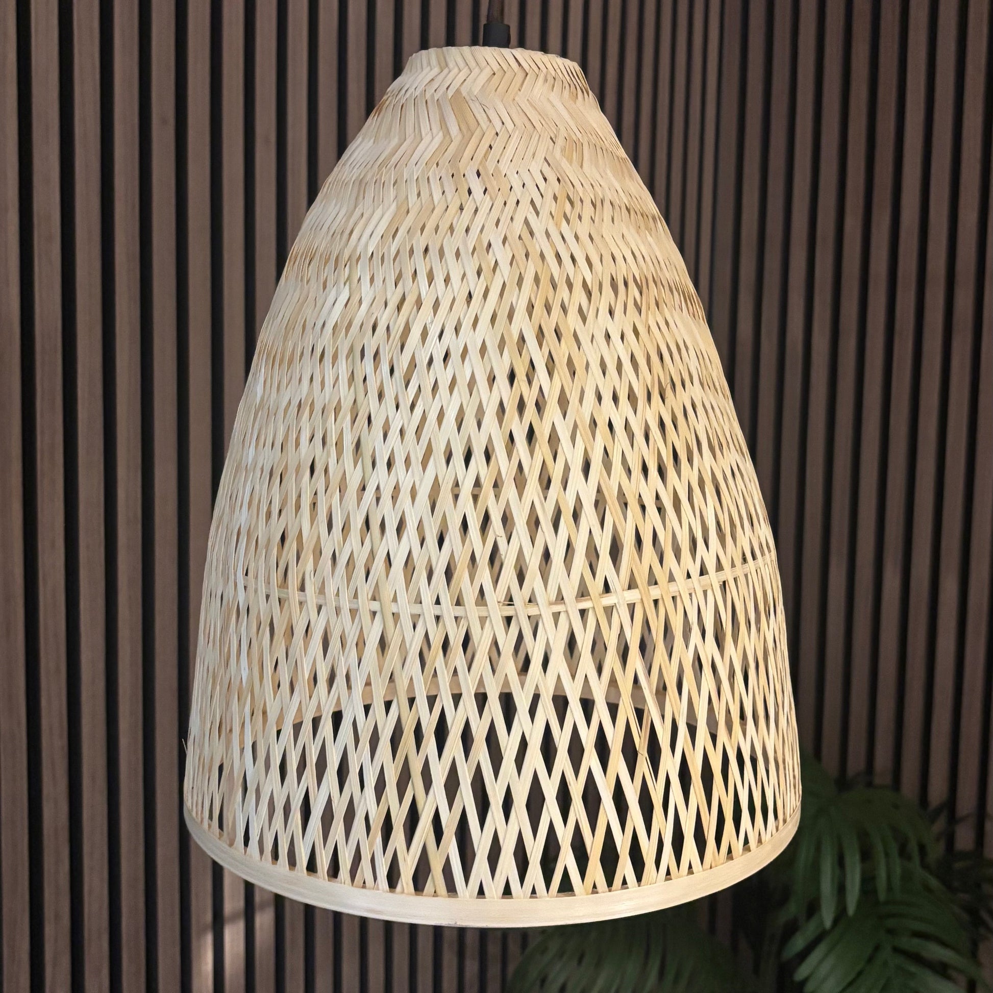 Woven rattan lampshade against a dark wooden panel background
