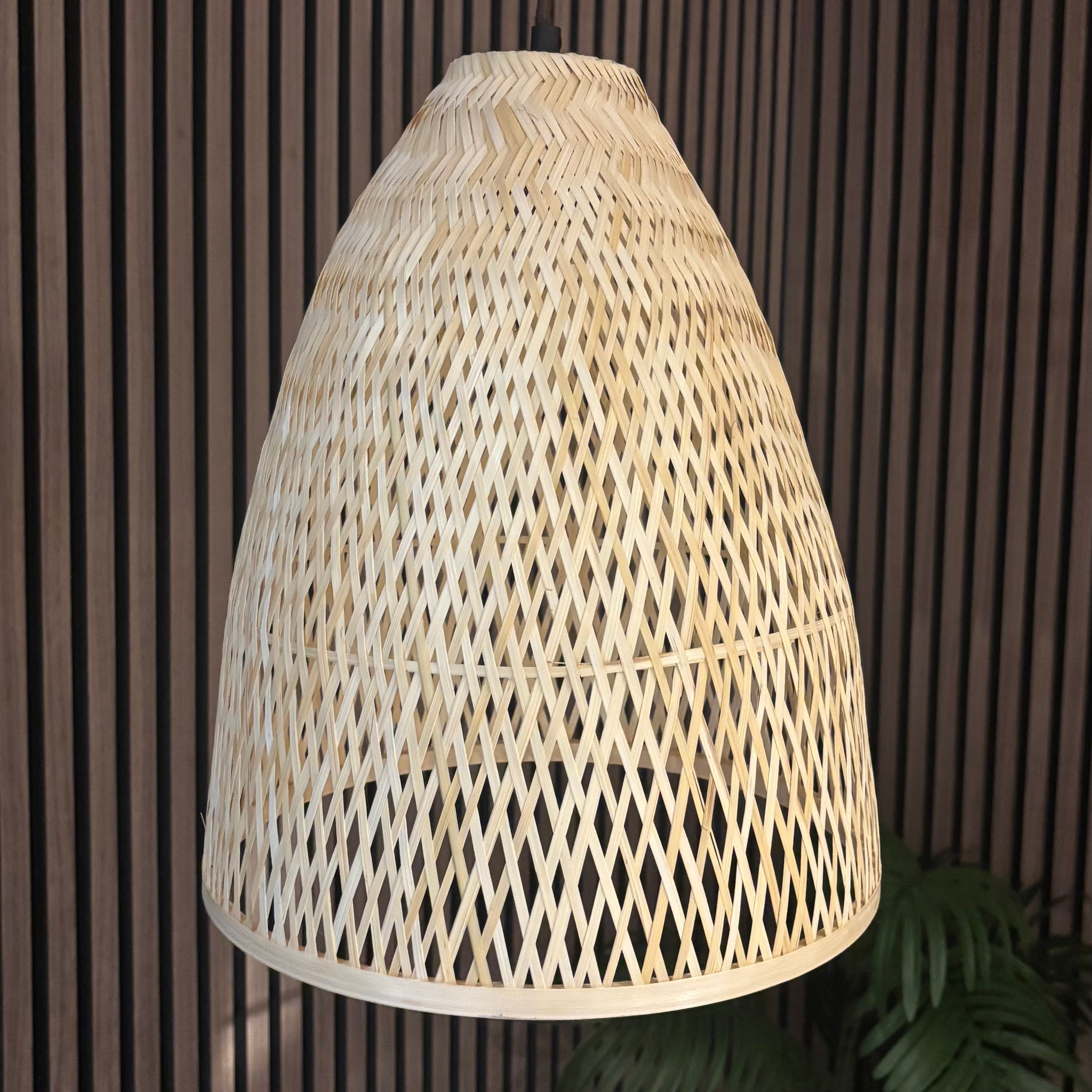 Woven rattan lampshade against a dark wooden panel background