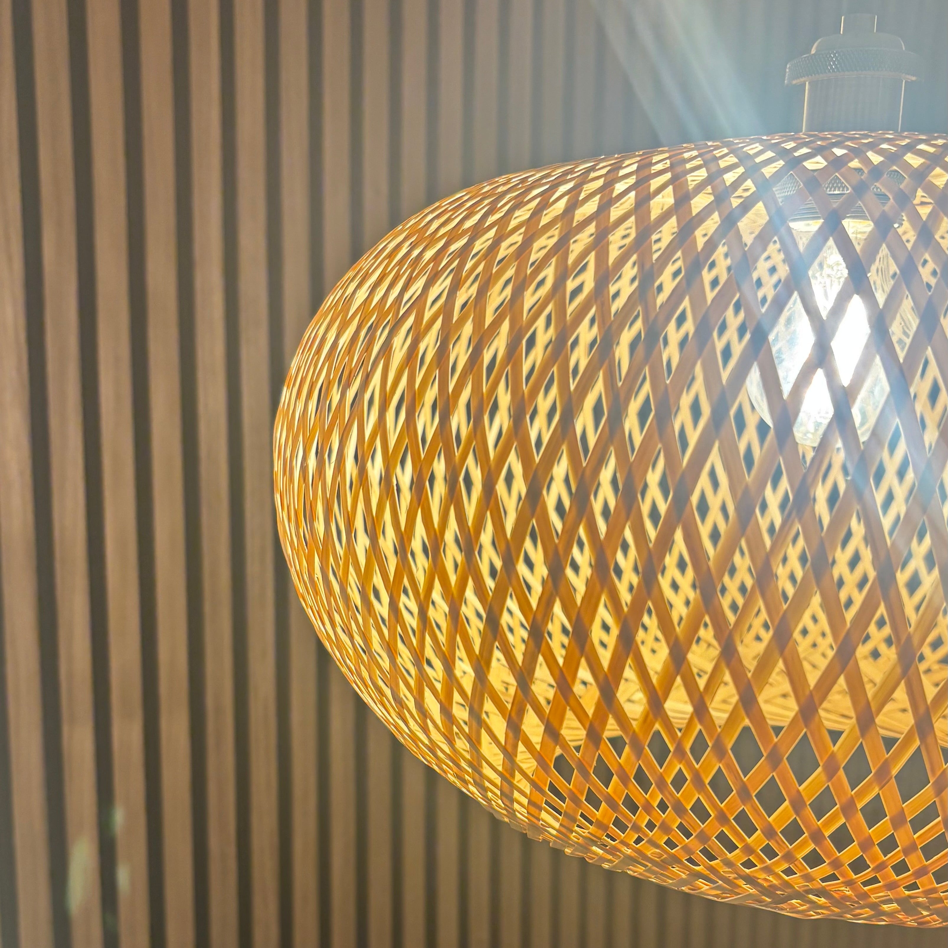 Woven pendant light hanging against a neutral background
