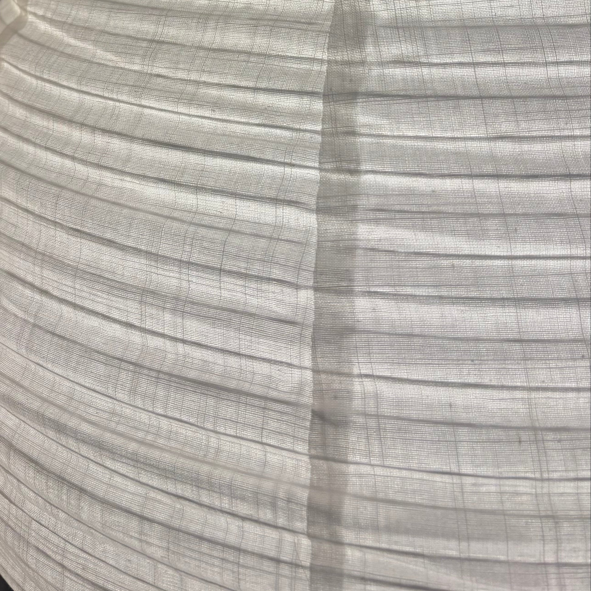 Close-up of a textured white lampshade against a dark background