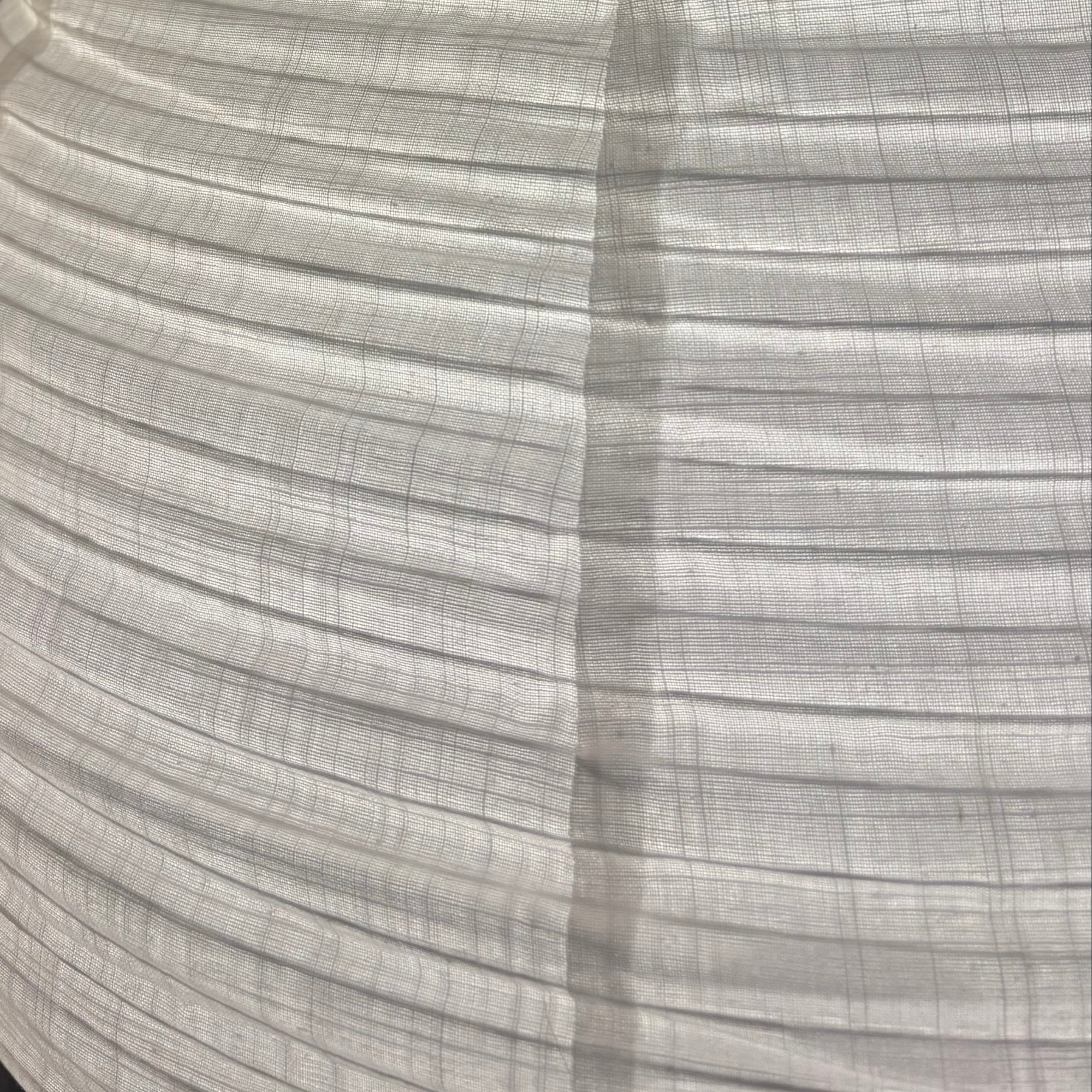 Close-up of a textured white lampshade against a dark background