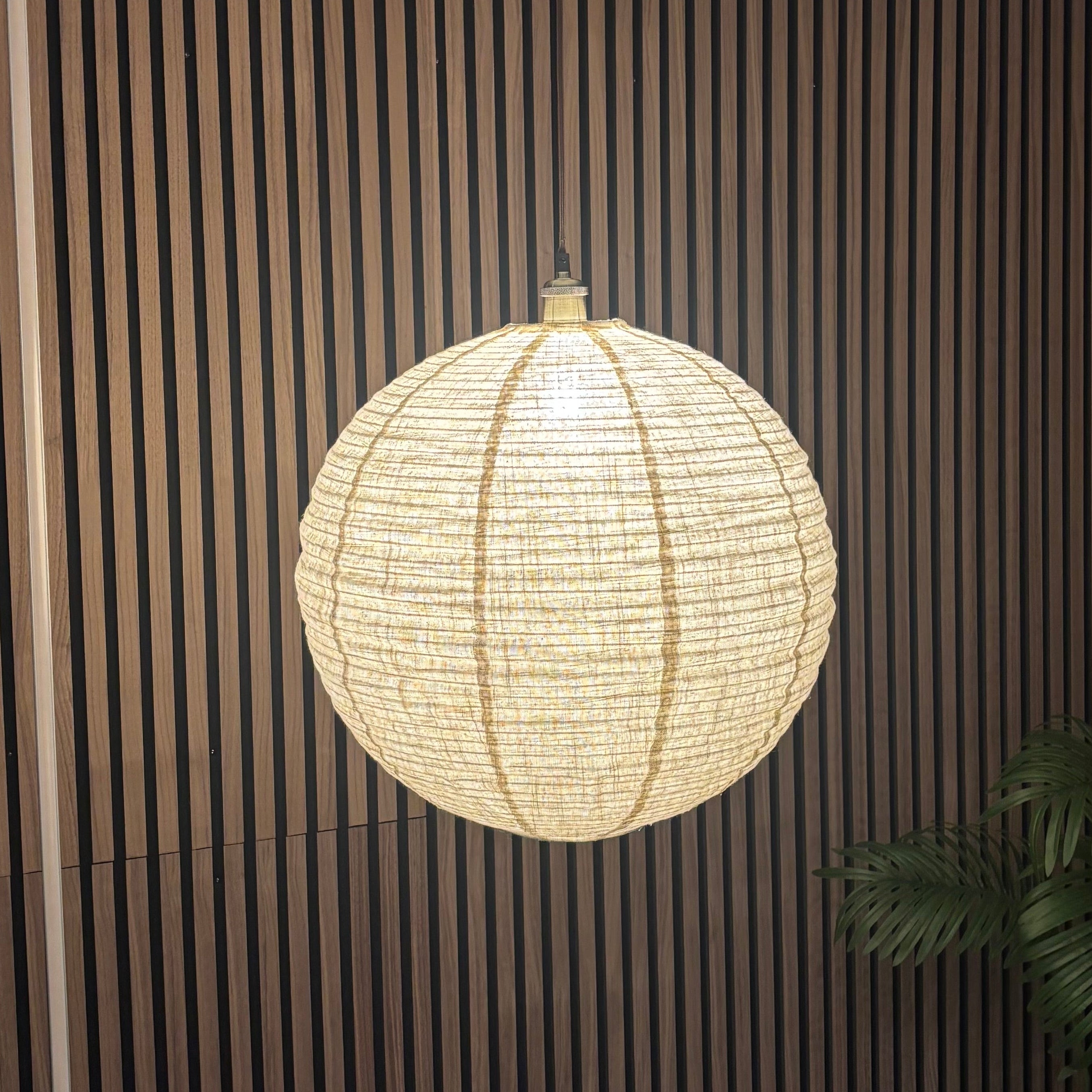 Modern interior with a hanging light fixture against a striped wall.