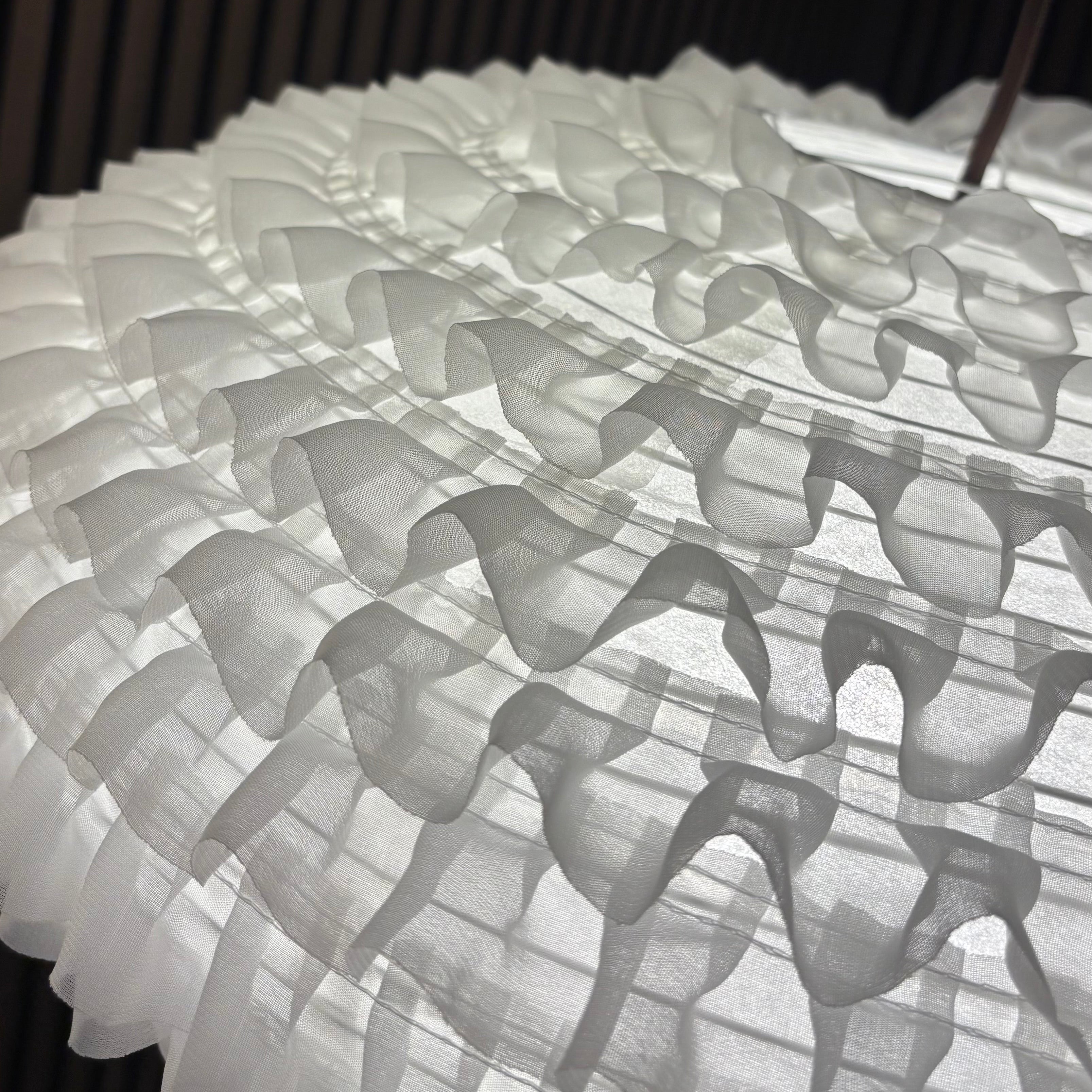 Close-up of a textured white fabric with a dark background