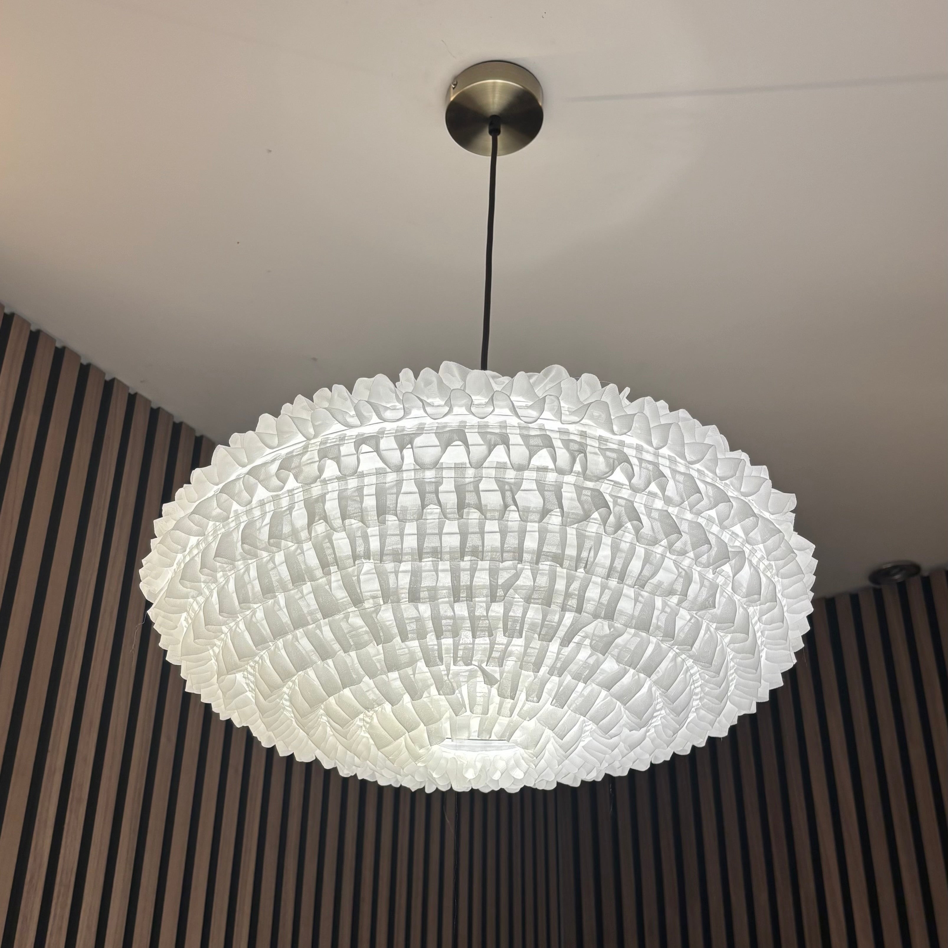 Chandelier hanging from a ceiling with a dark textured wall in the background
