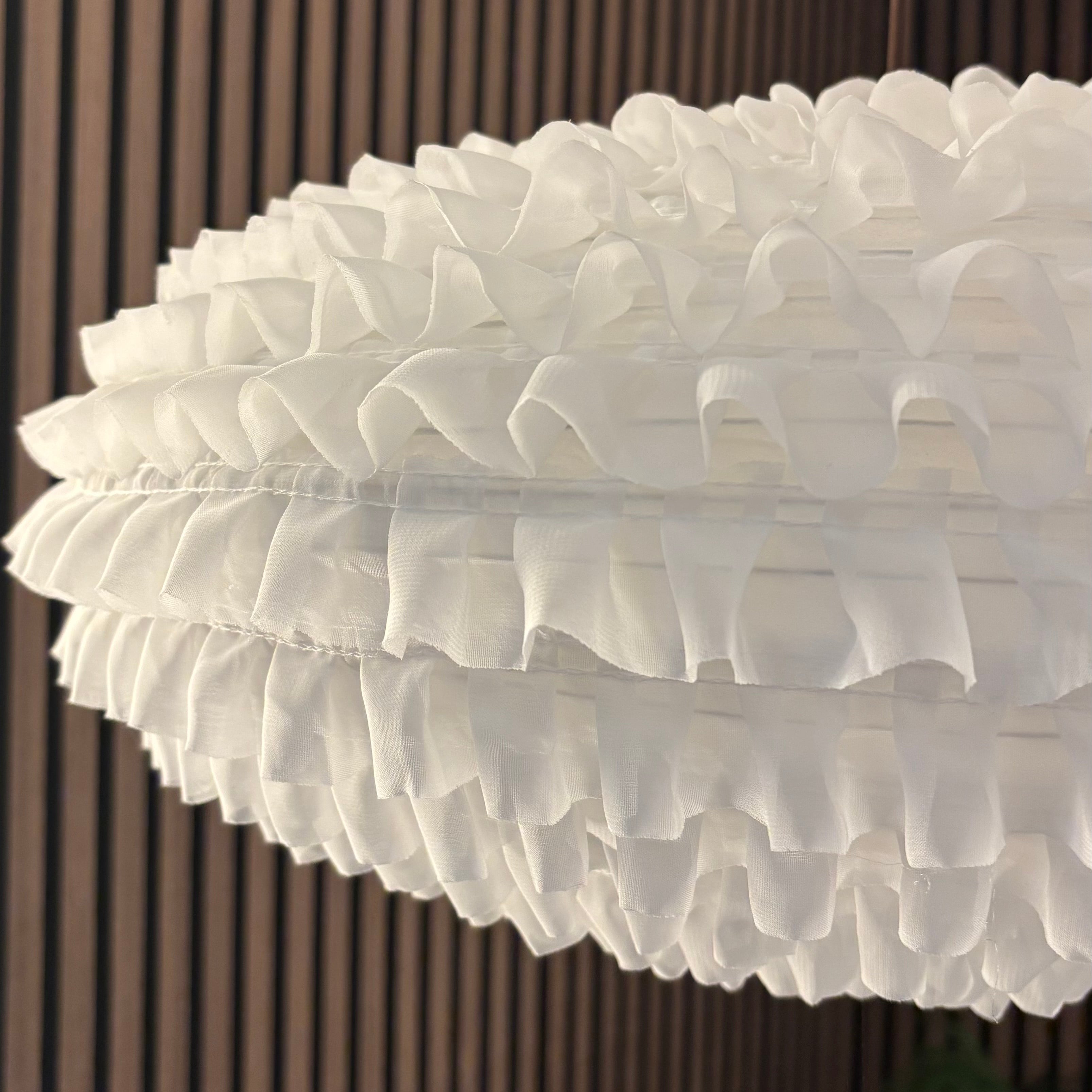 Close-up of a white floral arrangement against a striped wall.