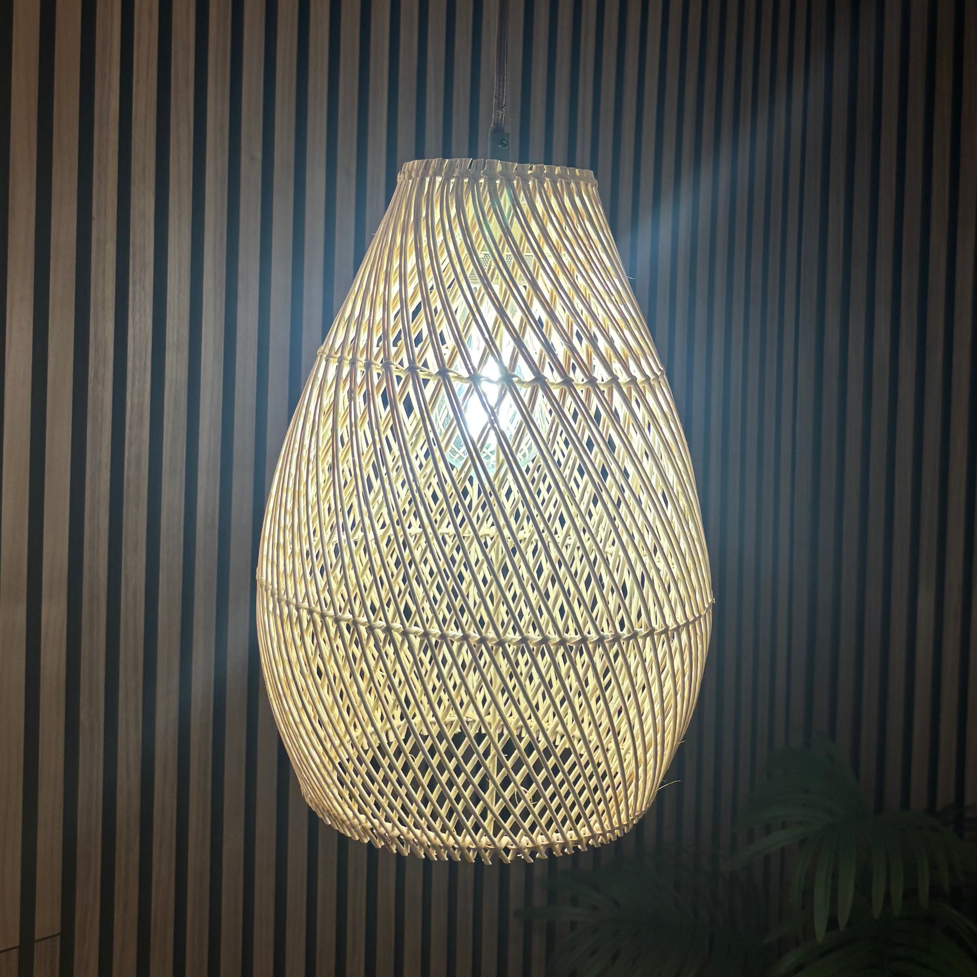 Woven pendant light hanging against a striped wall