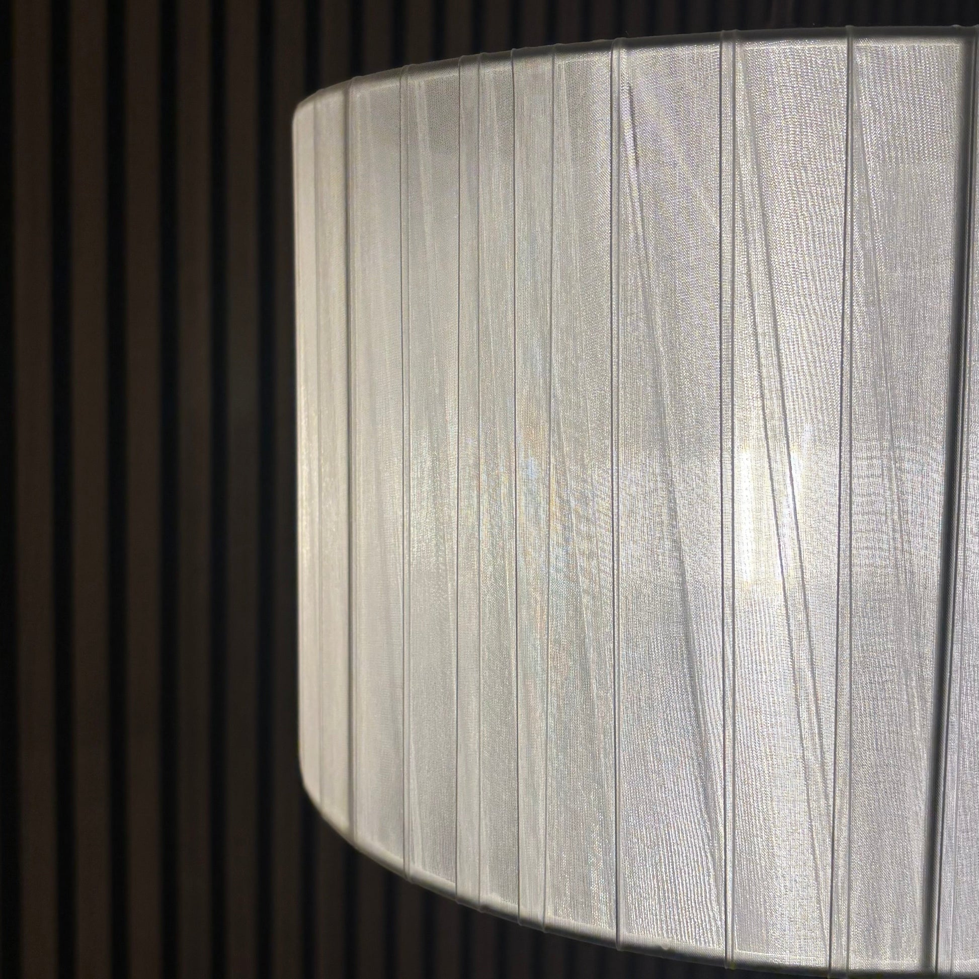 Close-up of a textured white lampshade against a dark background