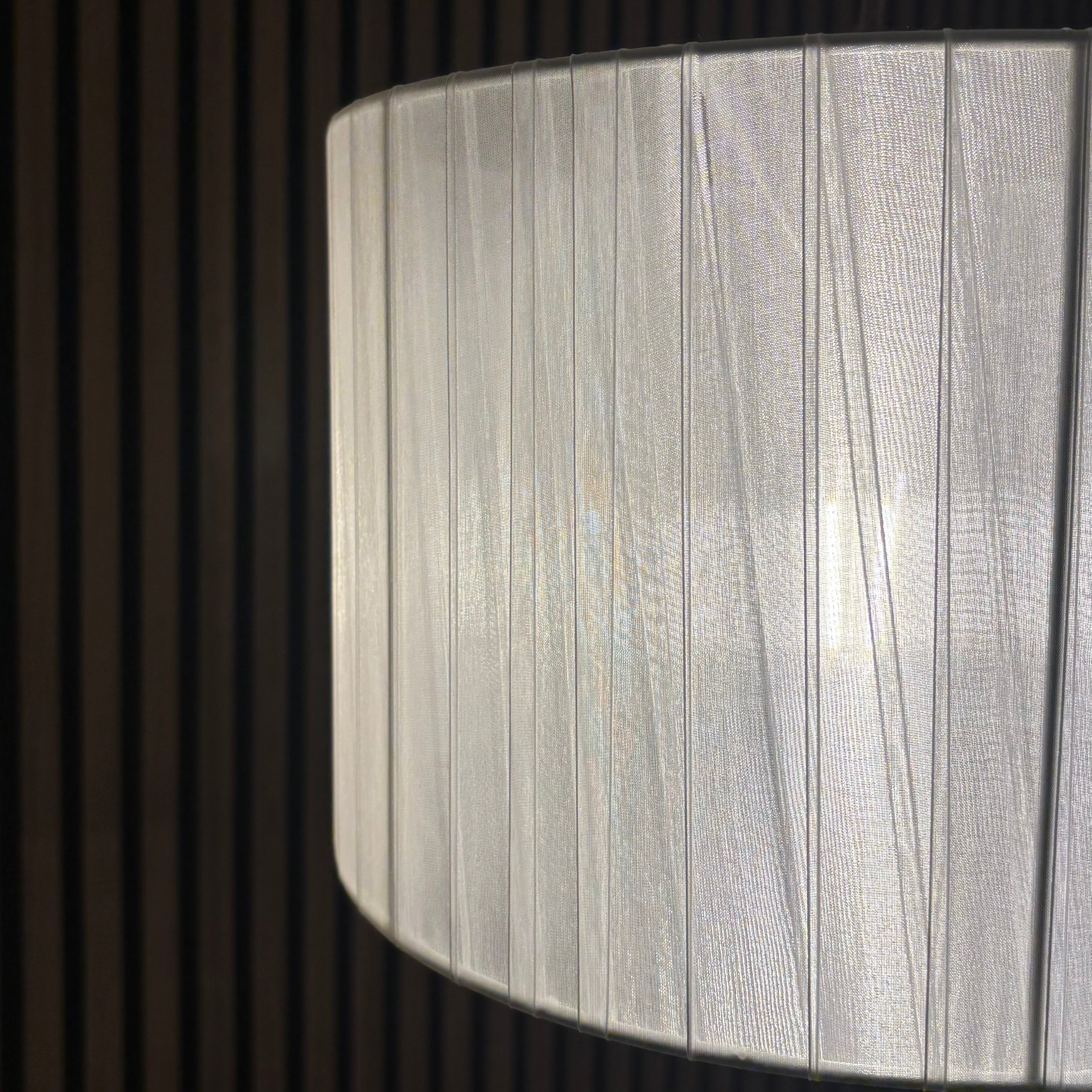 Close-up of a textured white lampshade against a dark background