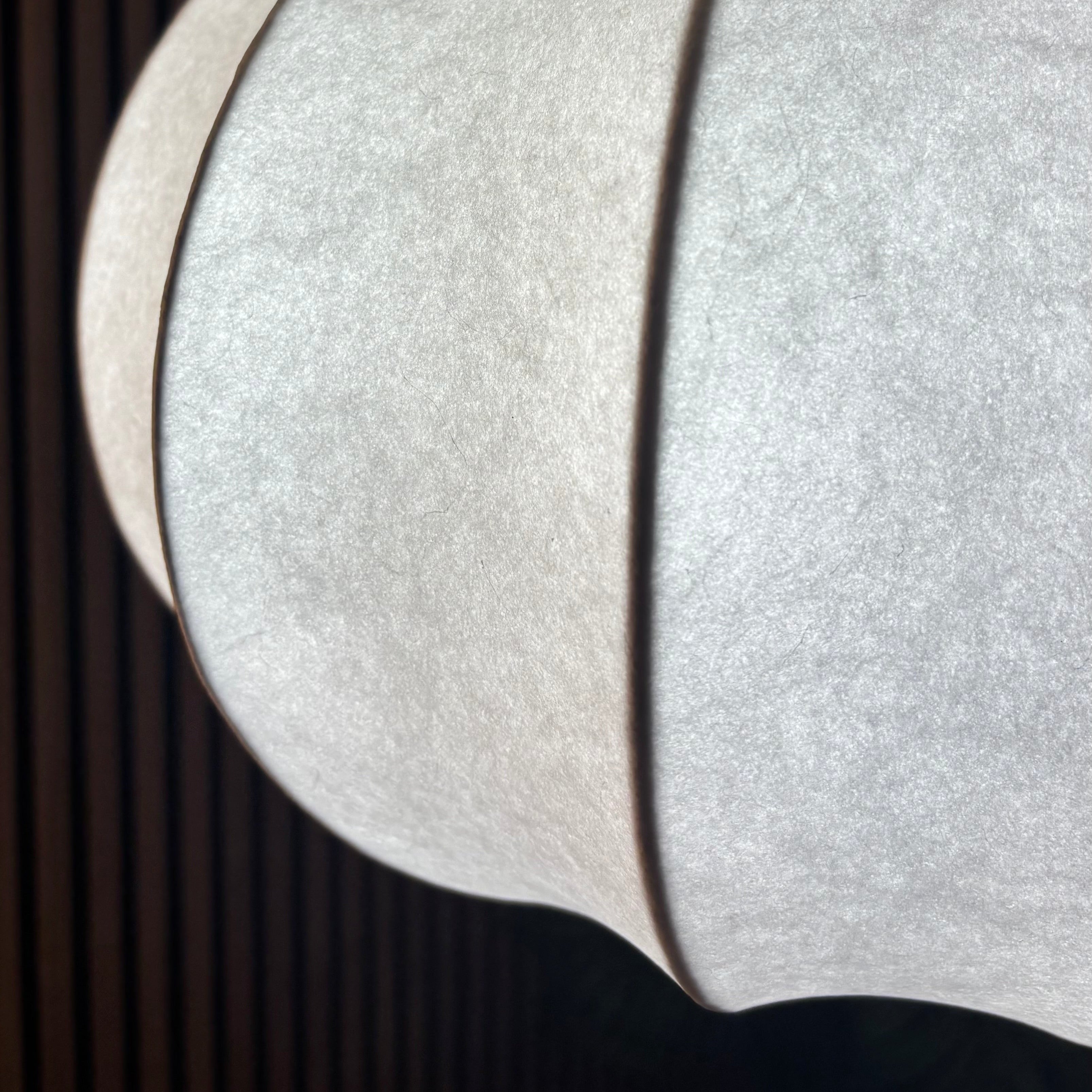 Close-up of a textured white lampshade against a dark background