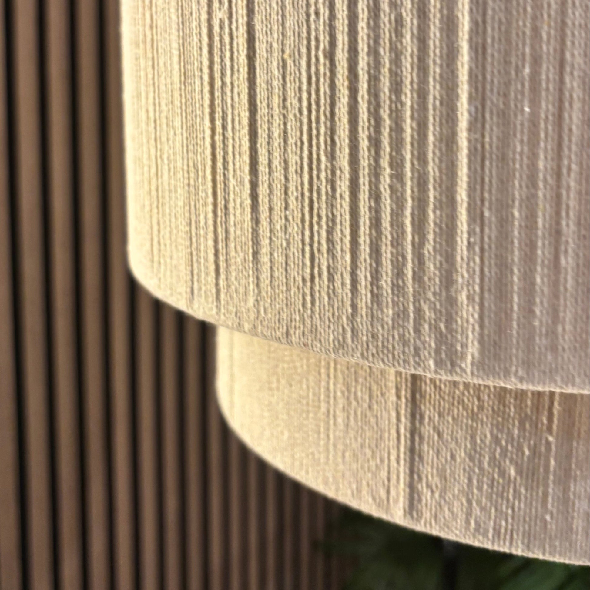 Textured lampshade against a wooden panel background
