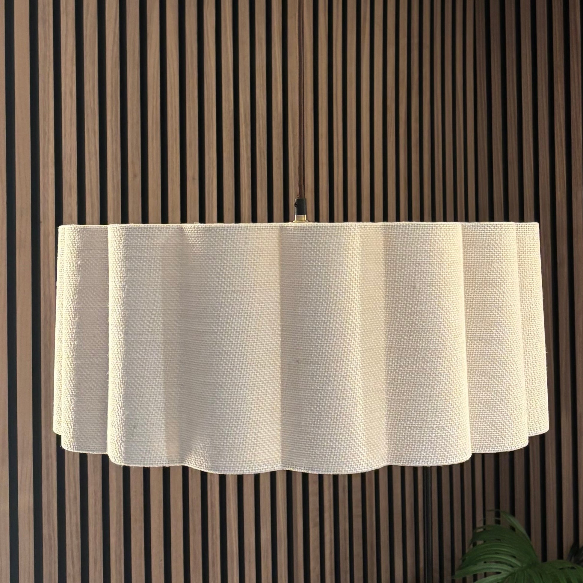 Ceiling light fixture in a room with striped walls and a plant.