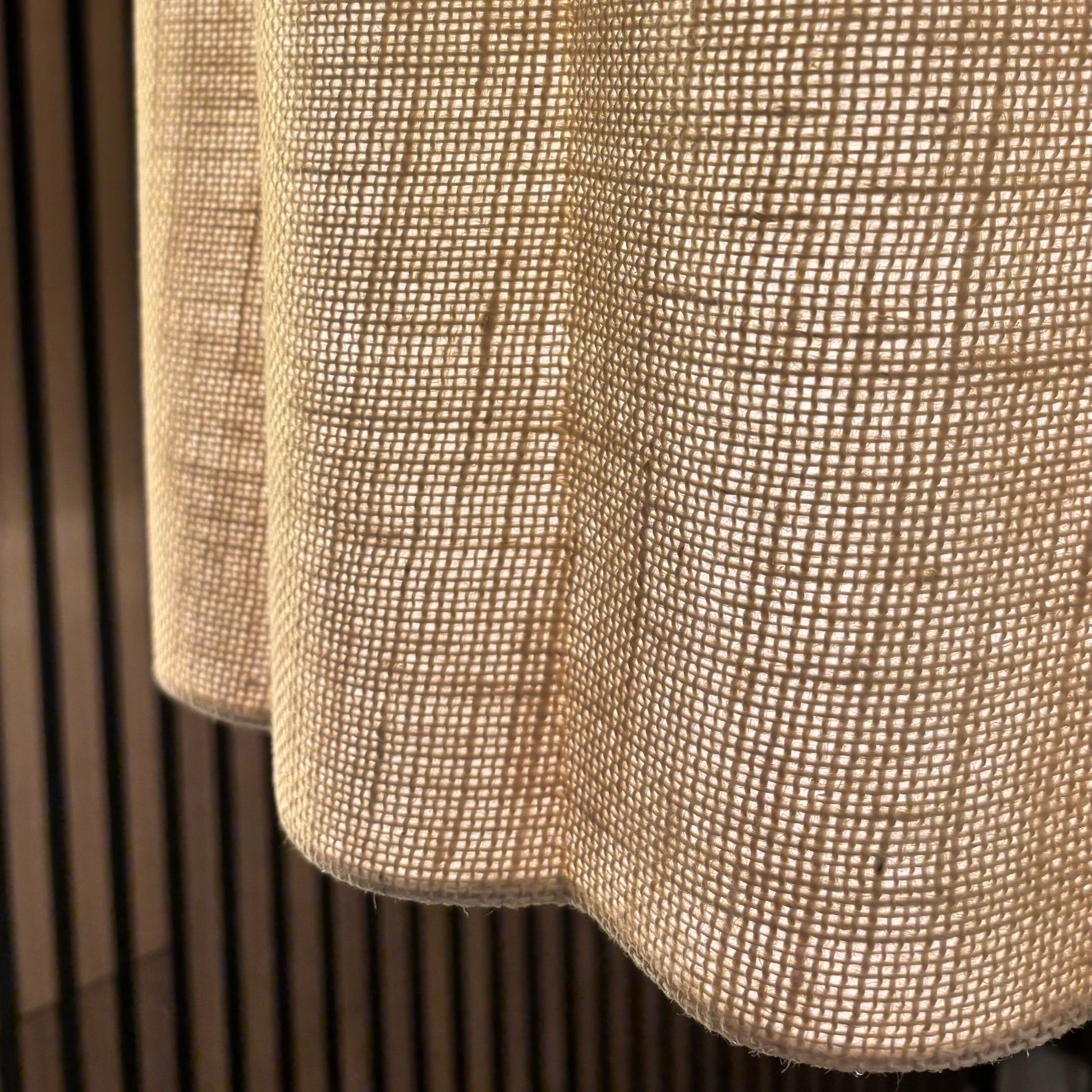 Three textured pendant lights hanging against a wooden panel background