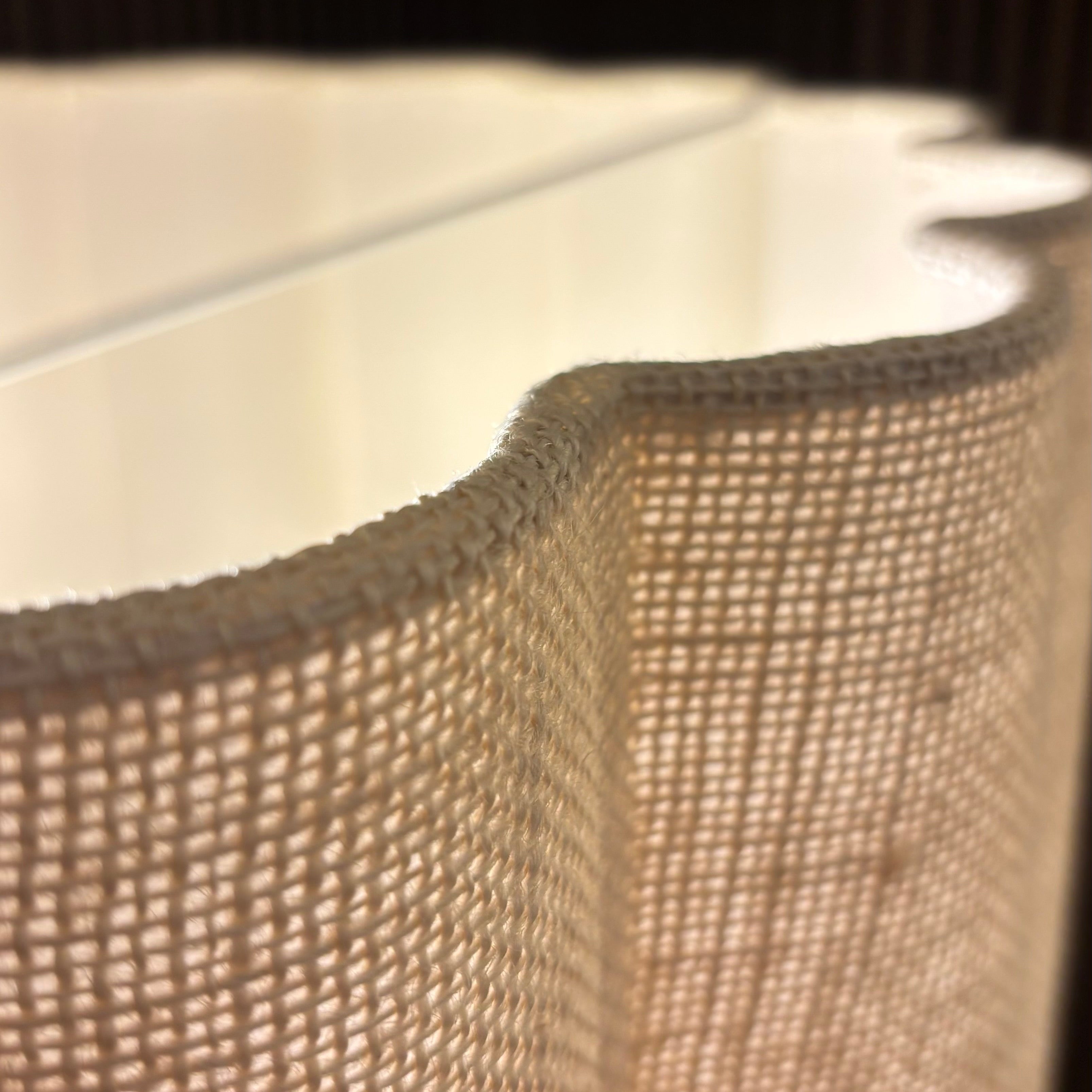 Close-up of a textured fabric edge with a neutral color palette.