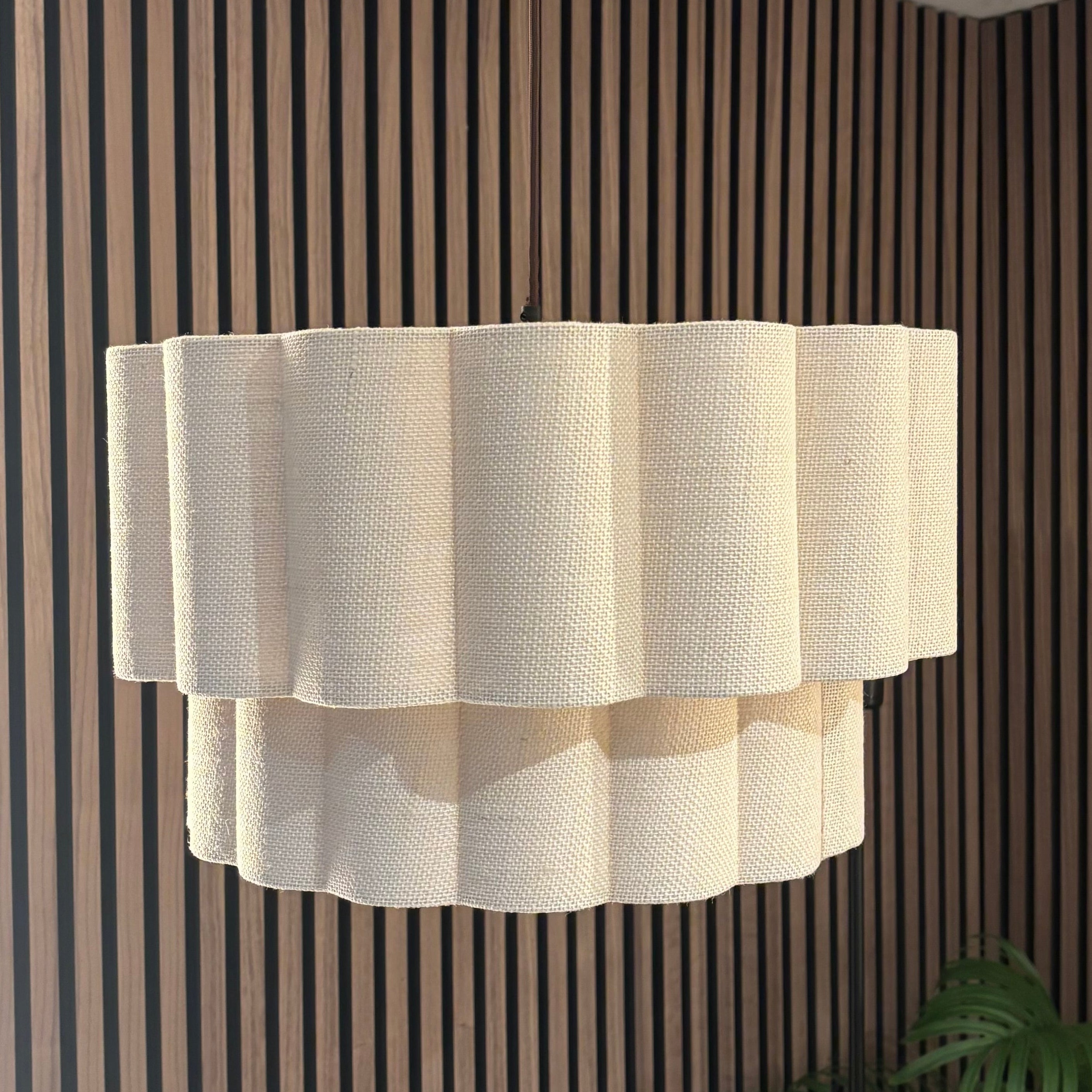 Modern pendant light fixture hanging against a striped wall.